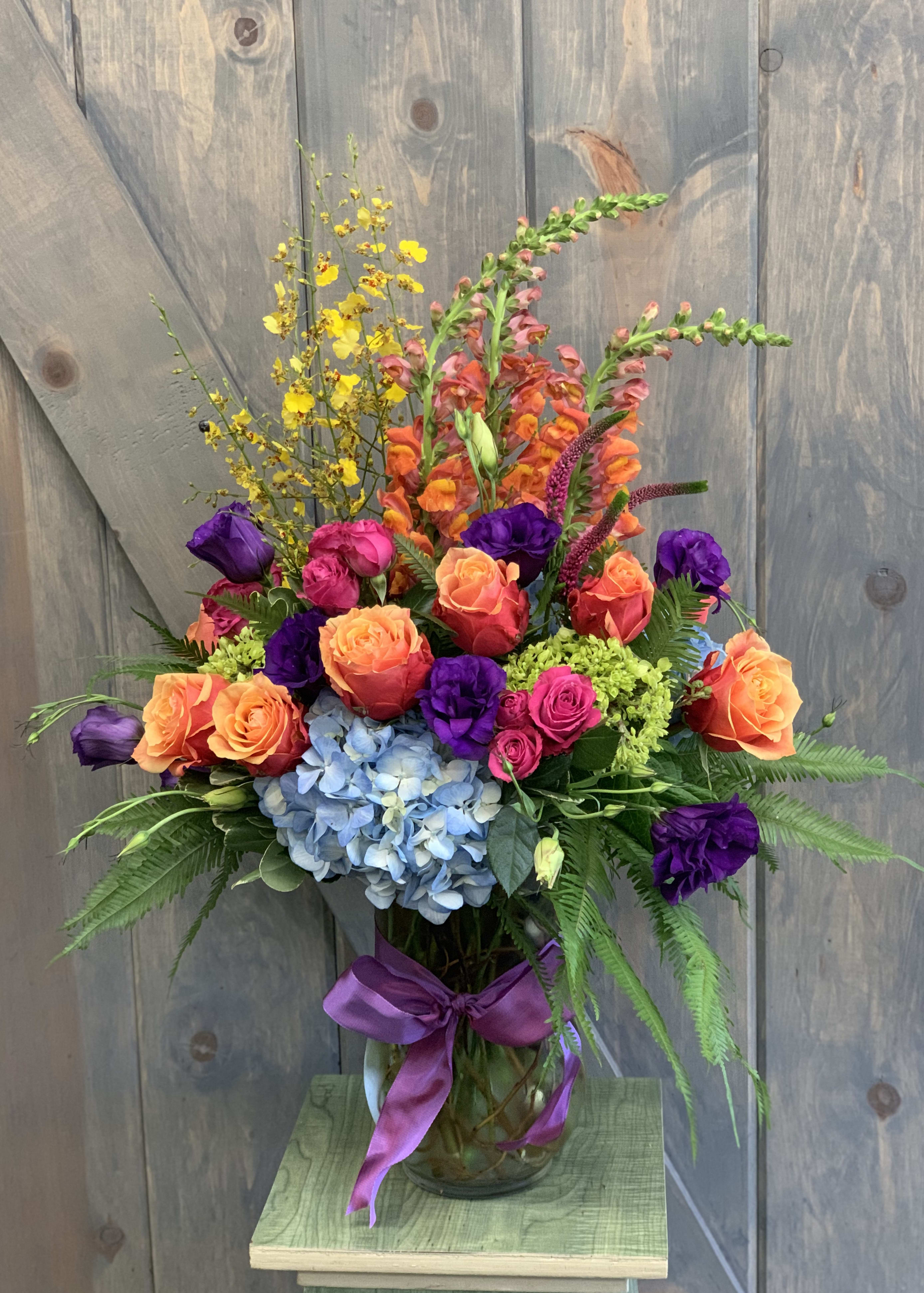 Painter Palette Painter Palette - This is a truly vibrant and uplift arrangement . The flowers included are Snap Dragons, Oncidium Orchids, Roses, Spray Roses, Hydrangea, Mini Green Hydrangea, Lisianthus, and Umbrella fern