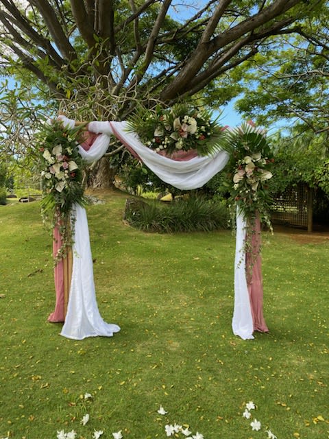 TROPICAL ARCH 8 - Bamboo arch, white + coral chiffon, areca + raphis palms, eucalyptus,  ivy, white anthuriums + rose sprays, roses, lisianthus.  3 arch sprays( to be reused as centerpieces) 