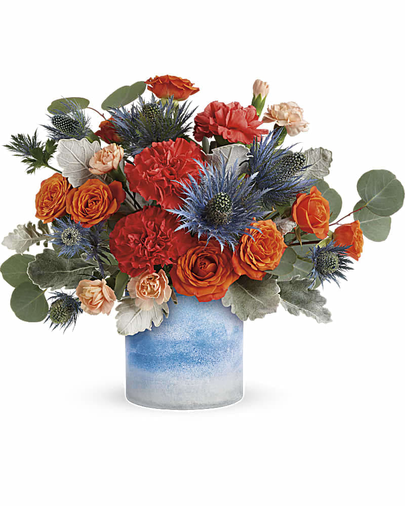 Teleflora's Standout Chic Bouquet - One of a kind! This standout mix of bold orange roses and chic blue eryngium is presented to perfection in a sky blue art glass vase with a unique frosted finish.