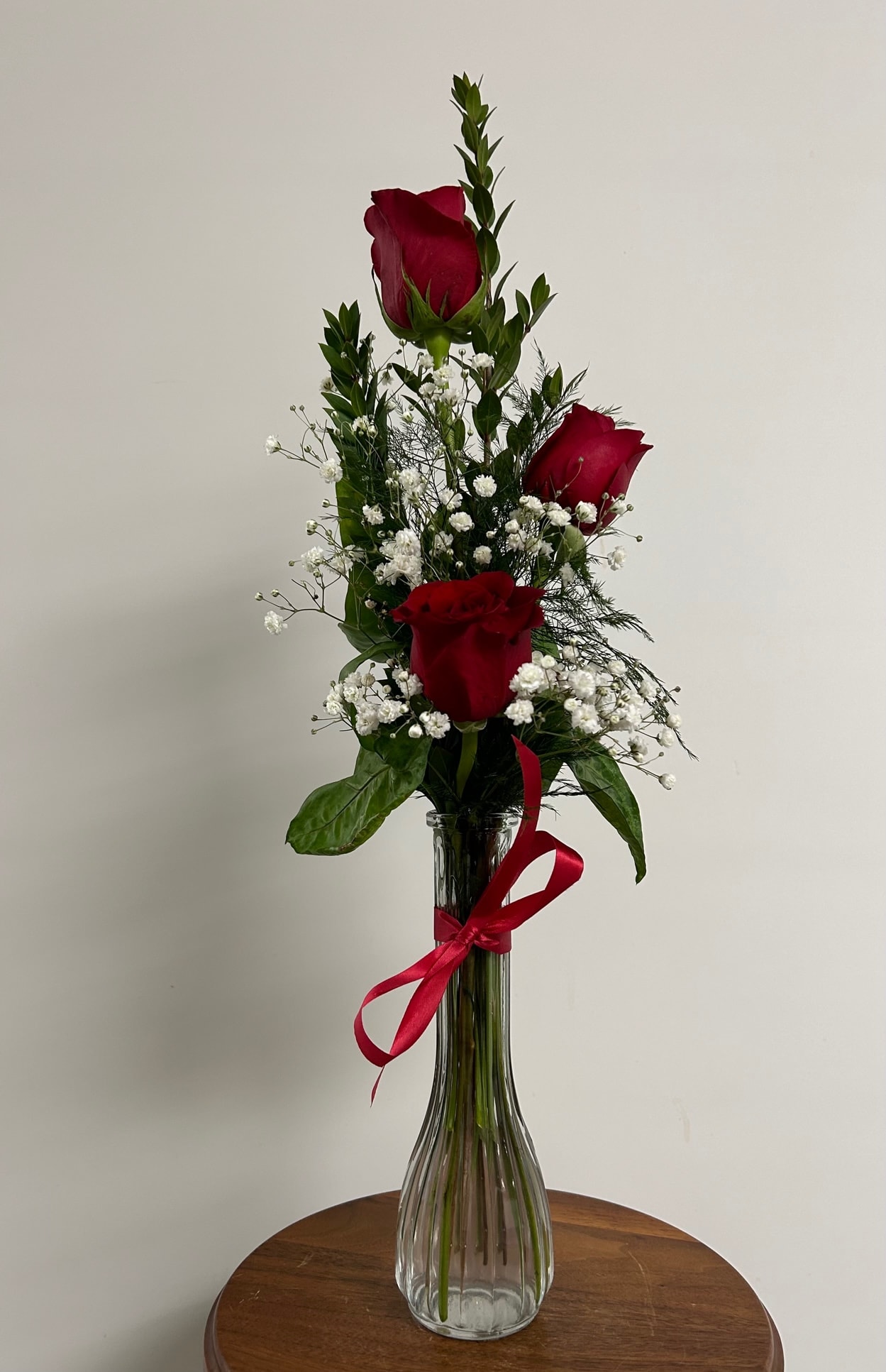  3 Red Roses - This bud vase of red roses is the perfect way to make someone's day. Three red roses arrive in a clear vase topped off with a ribbon bowtie!  As Shown : 3REDROSE      All prices in USD ($)      As Shown      3REDROSE 