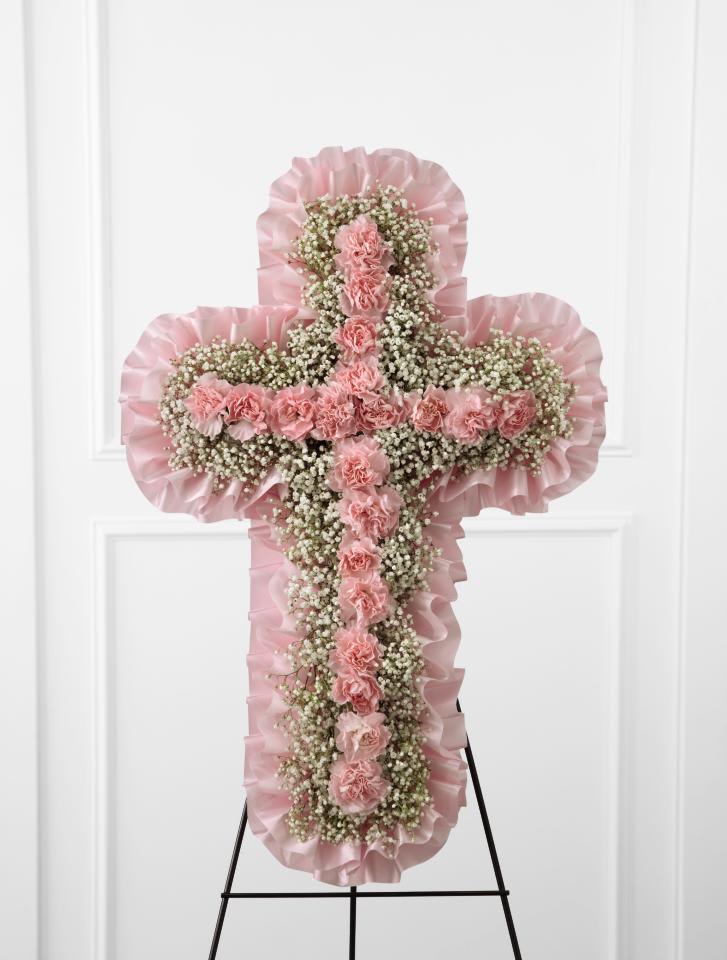 FTD Angel's Cross Easel - The FTD Angel's Cross Easel is a graceful tribute to honor the  life and faith of the deceased. Pink mini carnations and baby's breath  are lovingly arranged in the shape of a cross, accented with a pink  satin ribbon around the outside and displayed on a wire easel, to create  a wonderful way to express your love for the departed.   24&quot;&quot;h x 15&quot;&quot;w