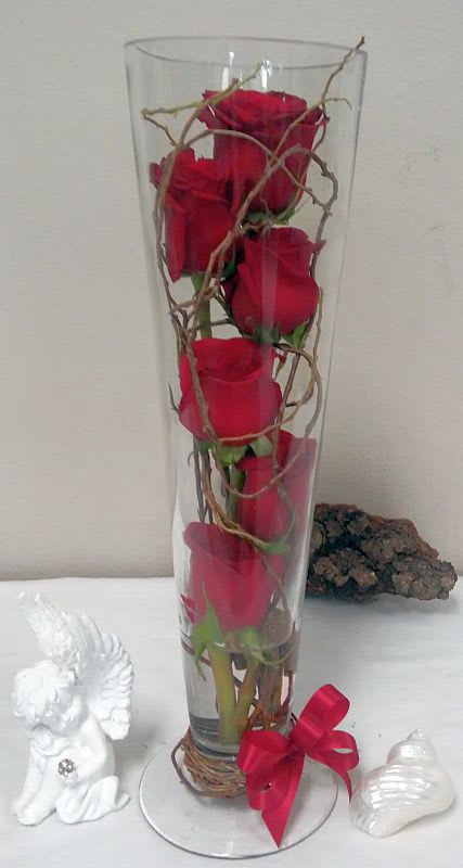Tower of Romance Tower of Romance - For a modern interpretation of a fresh rose arrangement, consider this sophisticated display of six red roses, symmetrically arranged with vines in a tall glass cylinder vase. It’s a unique and eye-catching display that’s sure to capture everyone’s attention. In special instructions you can request another color of roses if you want to.