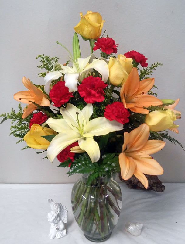Sunset Sky Sunset Sky - Add a bright touch to any room with a fiery mix of yellow, orange and red flowers – including roses and lilies – that’s guaranteed to warm up someone’s day. A bright floral mix that’s as pretty as a summer sunset.