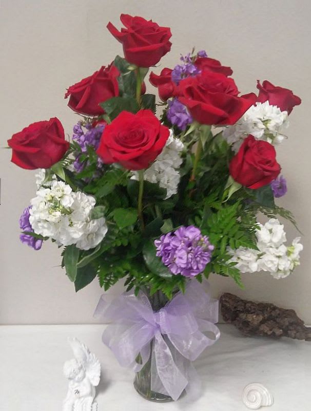 Roses in a Stock Filled Vase Roses in a Stock Filled Vase - Red roses with purple/lavender and white stock are two of the most elegant blossoms in nature; combined in one lovely floral arrangement, they create double the flower power! This is a gorgeous piece sure to impress.