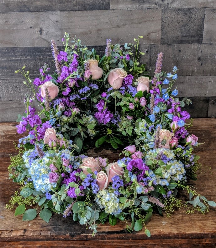 Mom's Garden of love - Shown as Standard Garden florals in soft color tones surround the urn.  Appropriate for the service *We custom design this arrangement and use the freshest flowers available the day of delivery. The arrangement in this picture is an example of the size and style and may not feature the exact product shown.*