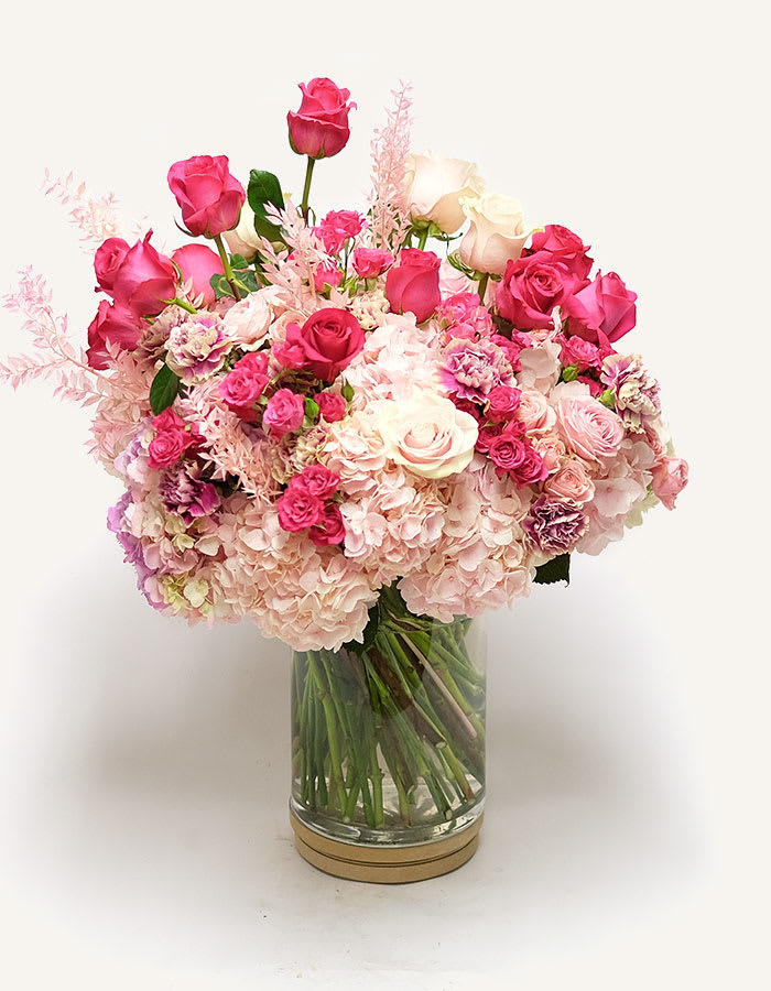 I Adore You Bouquet - This bouquet is the perfect way to tell someone they're one of your favourite people, whether its a partner or a close friend, because Valentine's is a celebration of all love. .A full bouquet of dark and light pink flowers in a tall clear vase.
