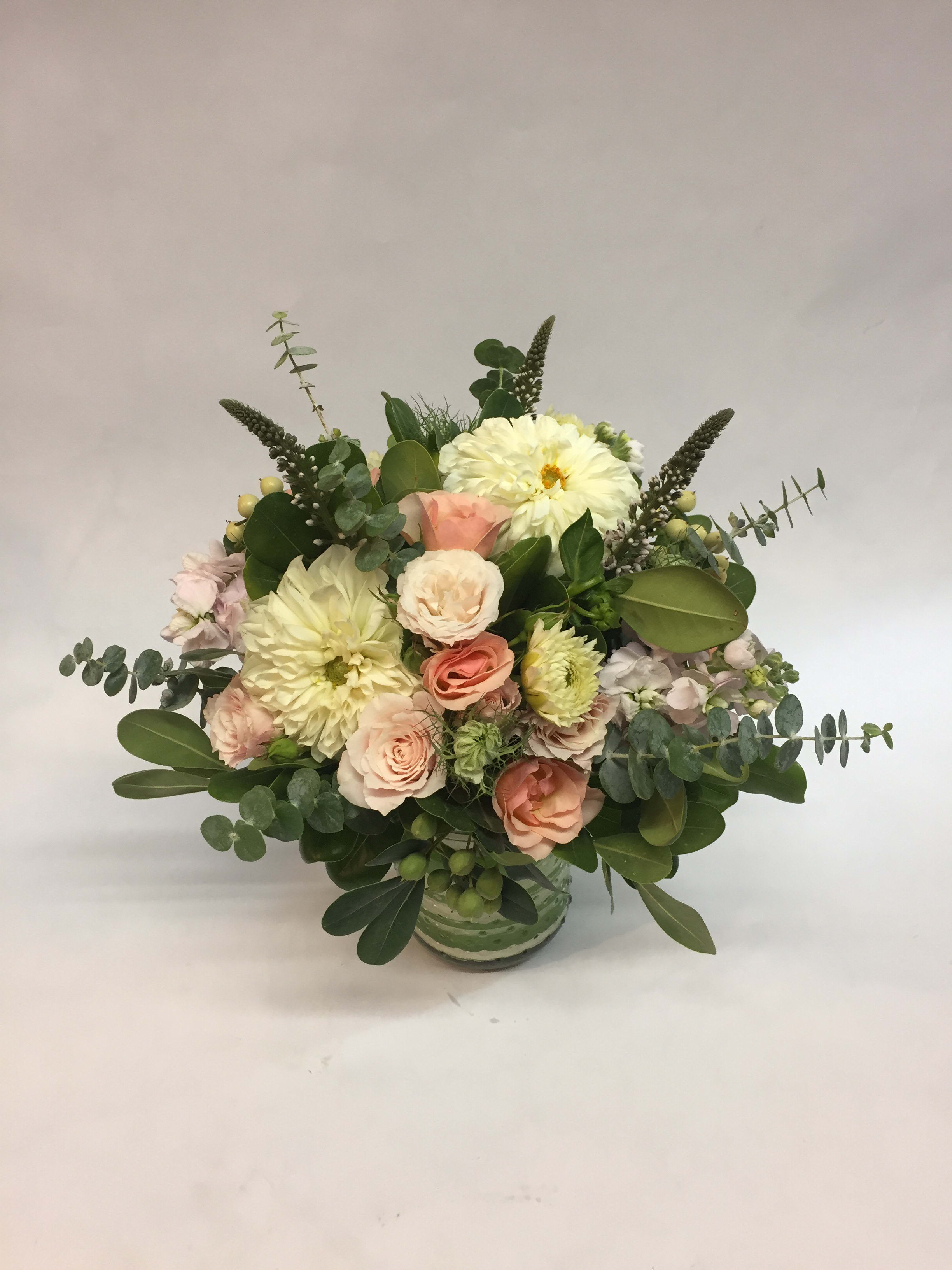 Brush of Love Brush of Love - This low arrangement comes complete with light pink spray roses, white dahlias (seasonal), , light pink stock, hypericum, spiral eucalyptus, seasonal greenery and various seasonal florals. (Some flowers may be subject to change depending on the season. We will contact you with available flower substitutions; please contact us with specific questions if you are concerned with flower availability, thanks!) Featured arrangement: $88.00 (Regular Price)