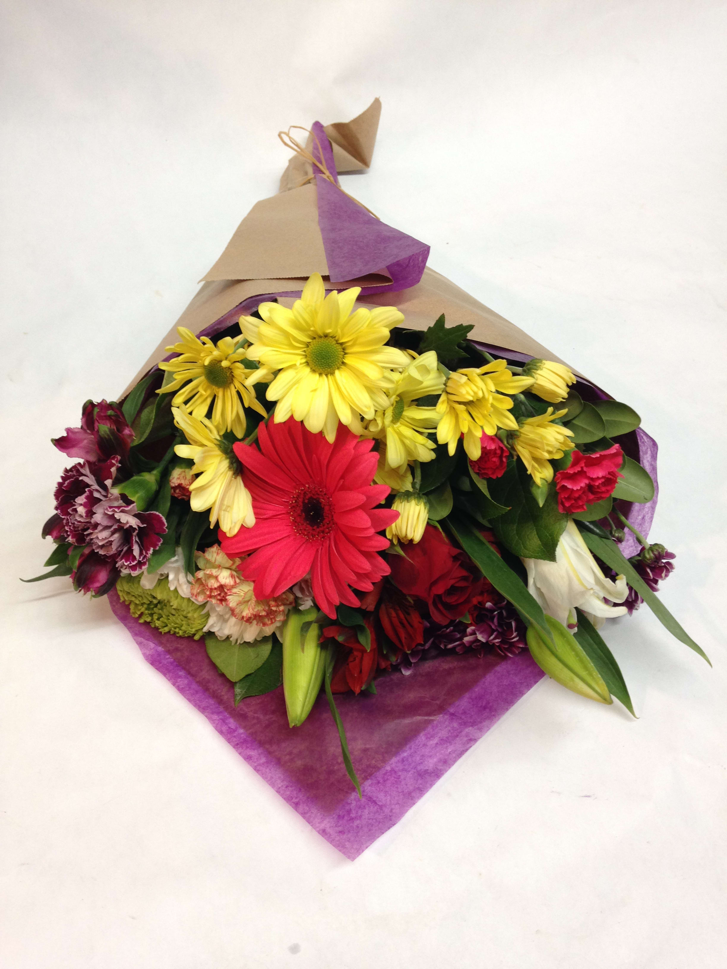 Local Mixed Bouquet - Our local mixed bouquet can be wrapped for $65.50. Complete with lilies, roses, gerbera daisies, alstromeria, carnations, mums, spider mums and greens.  (Some flowers may be subject to change depending on the season. We will contact you with available flower substitutions; please contact us with specific questions if you are concerned with flower availability, thanks!)  Featured bouquet: $78.50 (Regular Price)