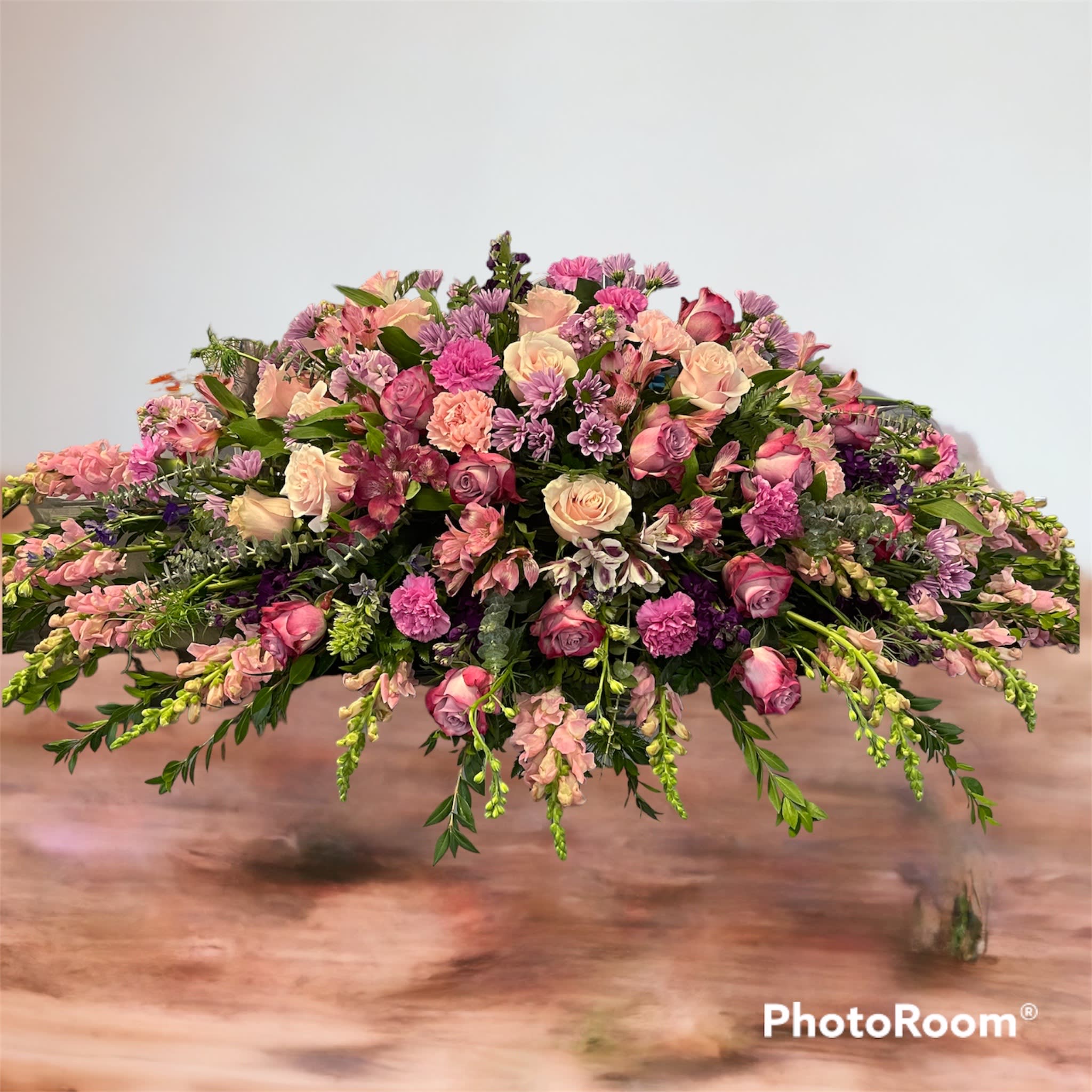 Lavender and pink Casket spray - Mix of pink and lavender flowers, seasonal changes may be made.