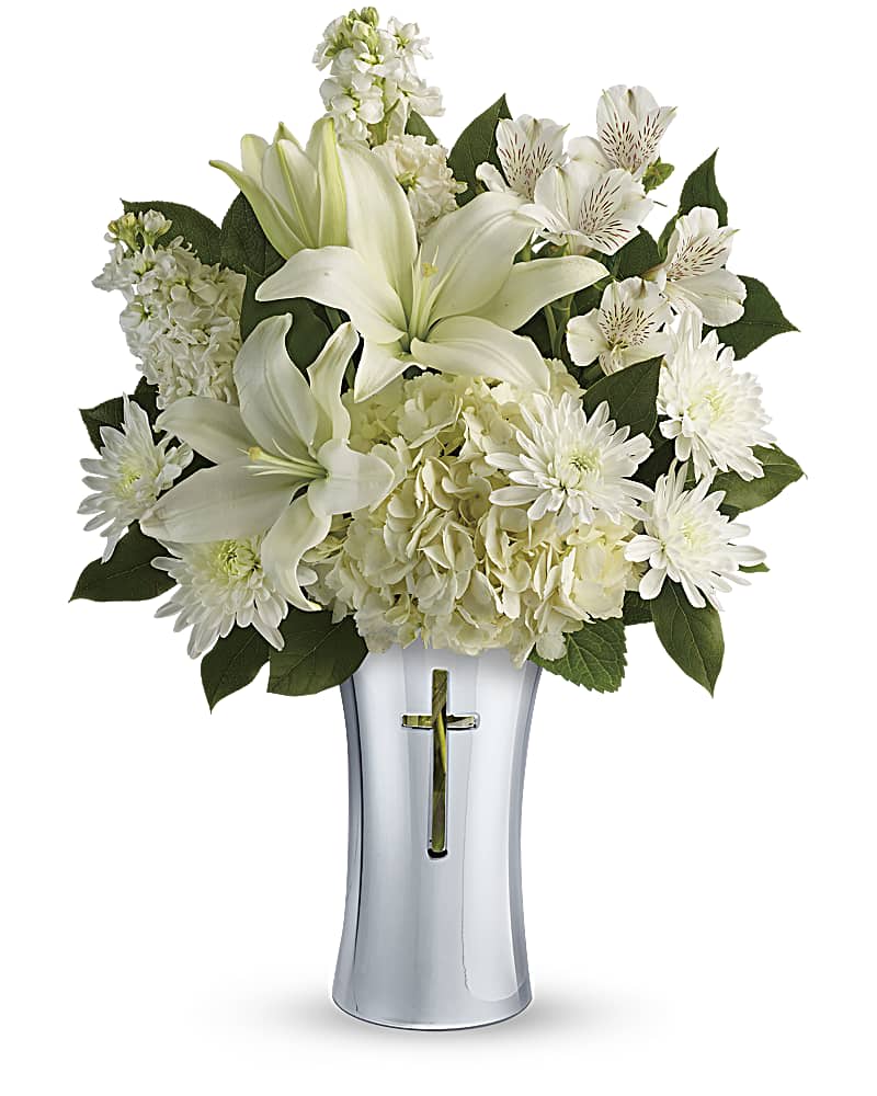 Shining Spirit Bouquet - A shining tribute to a life well lived, this pure white bouquet of hydrangea and lilies is arranged in a beautiful ceramic vase with gleaming metallized finish and reverent cross cut-out. It's a lovely gift of remembrance for the home or service. White hydrangea, white asiatic lilies, white alstroemeria, white stock, and white cushion spray chrysanthemums are accented with lemon leaf.