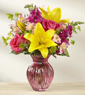 Happy Spring™ Bouquet - A combination of blushing hues and sunlit warmth, this spring bouquet blossoms with love and gratitude to make the season brighter with each hand-picked flower! Hot pink roses and brilliant yellow Asiatic Lilies will capture your recipient's every attention, surrounded by 