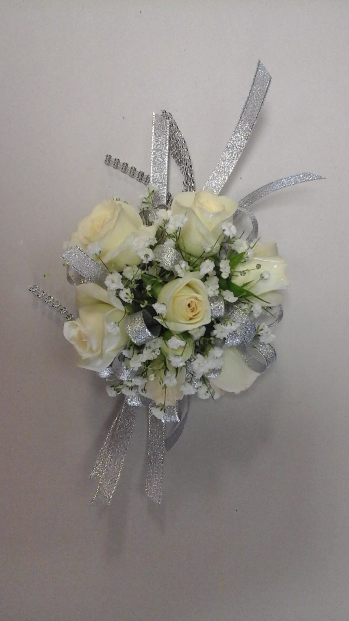White roses Corsage White roses Corsage - This corsage made with white spray roses and baby breath finish with silver ribbon.
