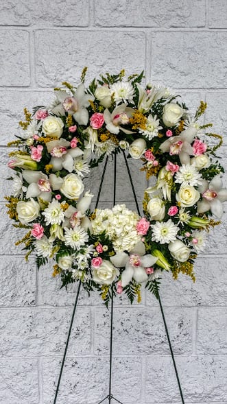 All white wreath for memorial service with lilies and roses