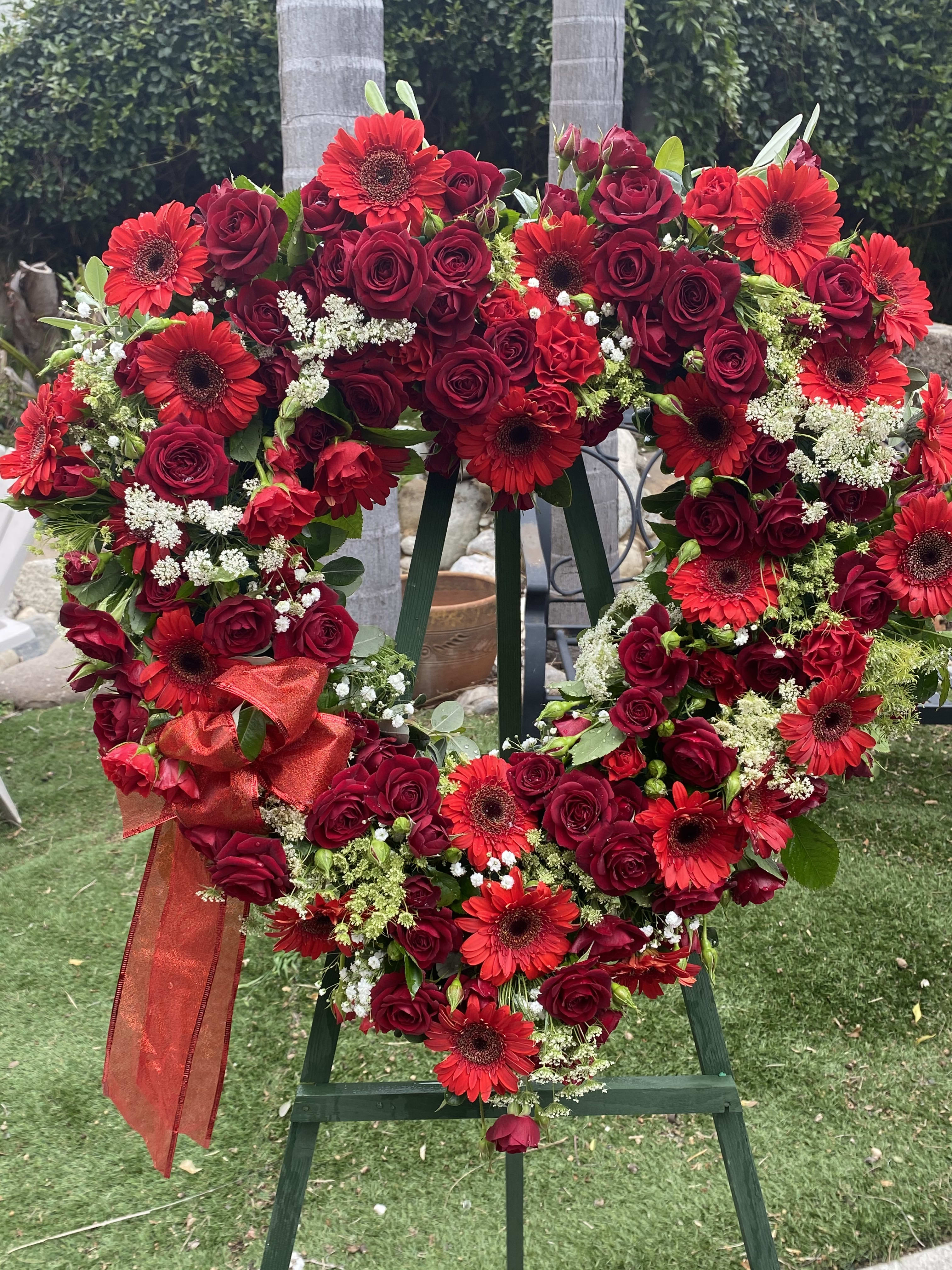 HEARTFELT BLESSING SPRAY - A BEAUTIFUL ARRAY OF RED TONES, FEATURING ROSES. STANDS ON A 5 FOOT EASEL...