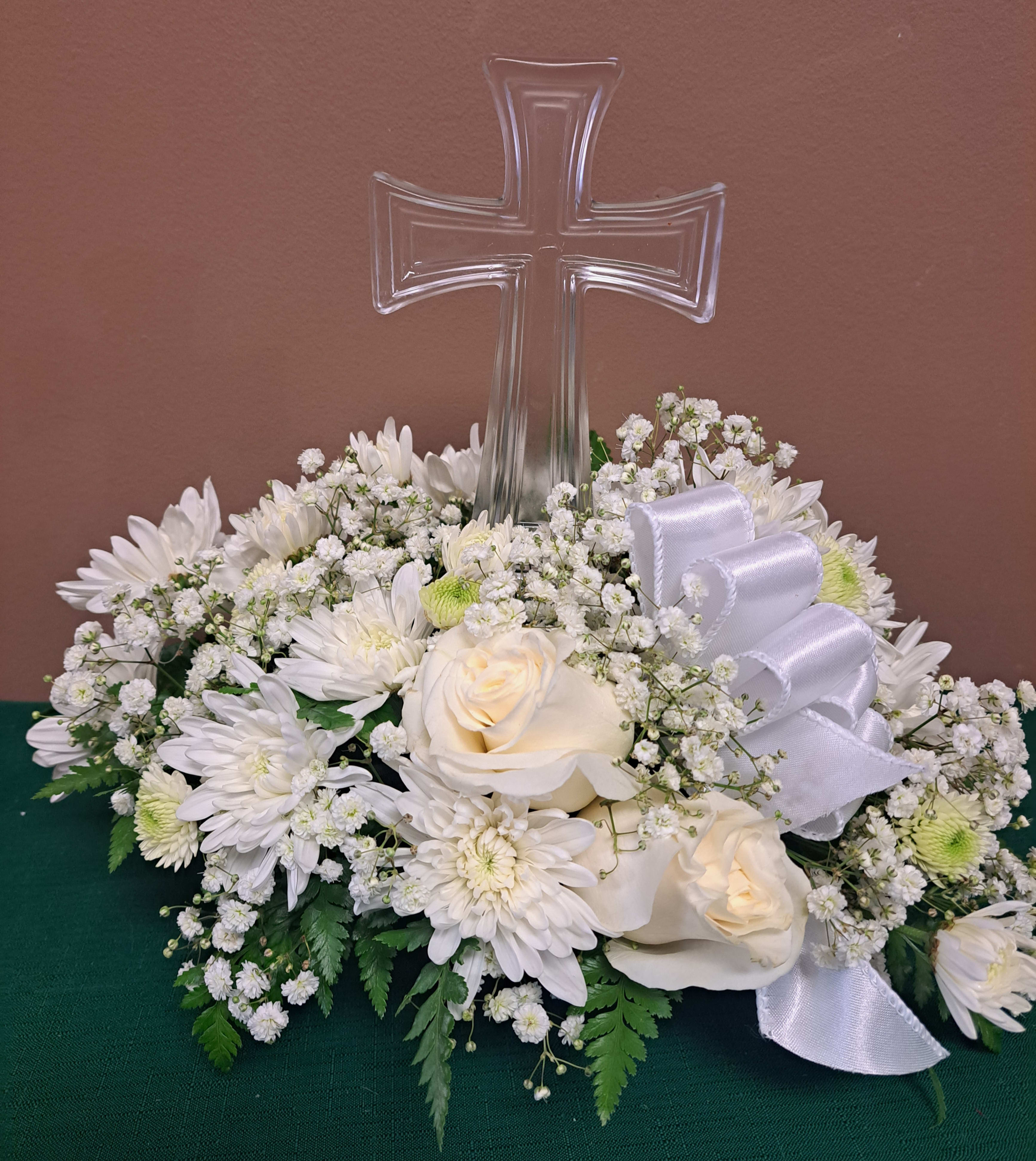 Simplicity - A beautiful way to remember a loved one. A crystal cross in the middle of a mixture of simple white flowers. 