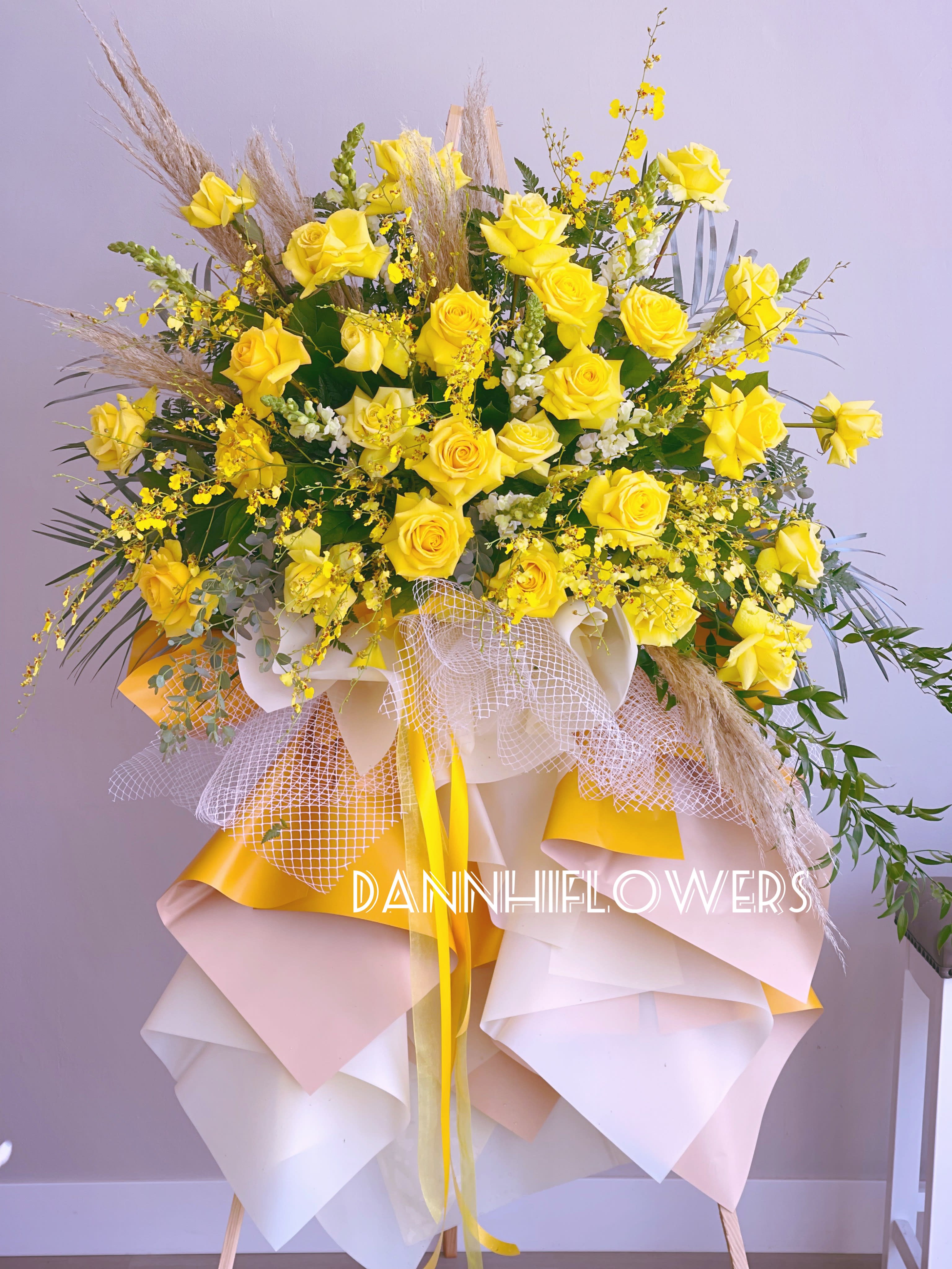 Congratulations flowers 01 - Yellow roses, oncidium orchids and pampas create an trending flowers arrangment on stand with paper wrap design.