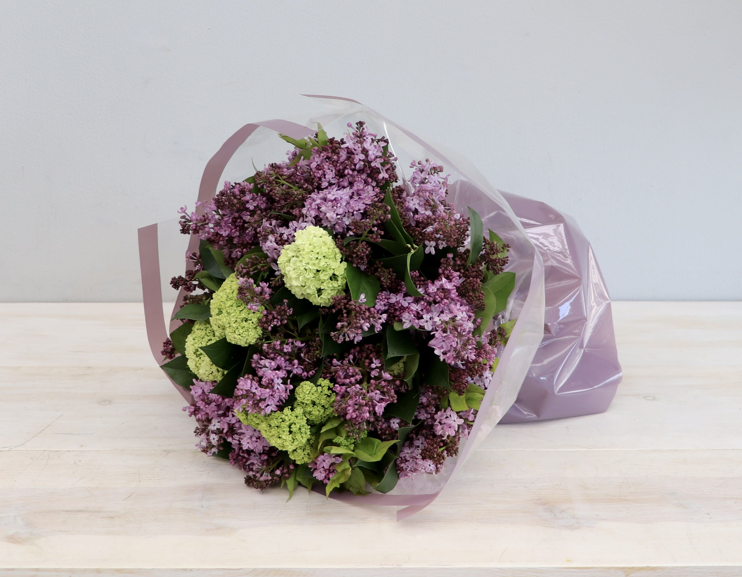 Classic Lilac Bouquet - My Glendale Florist - Dozen stem of our purple lilacs paired with seasonal greens. This is in the standard size. Deluxe is 50% more and double the size and quantity for premium. Lilacs will only be available for a short time. Make sure to get yours before the short season is over. 