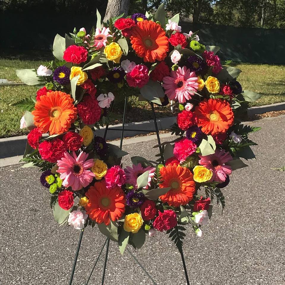 Customizable Open Wreath - This 24&quot; open wreath is made of pinks, orange, yellow and a splash of red. Your loved one's favorites will be honroably arranged for a &quot;never ending&quot; display of color. 
