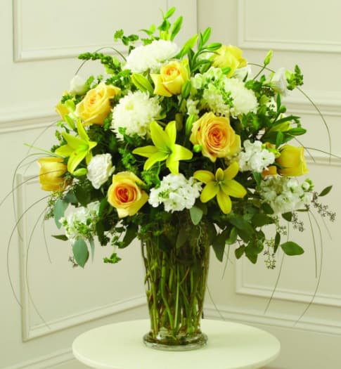 Yellow and White Arrangement - Extend your sincerest sympathy in comforting soft tones with our Yellow Sympathy Vase arrangement. Yellow roses and lilies adorn this bouquet, while blooms of fresh white flowers are spread throughout them to accentuate a sense of calm. The balance is what makes this arrangement truly special. 