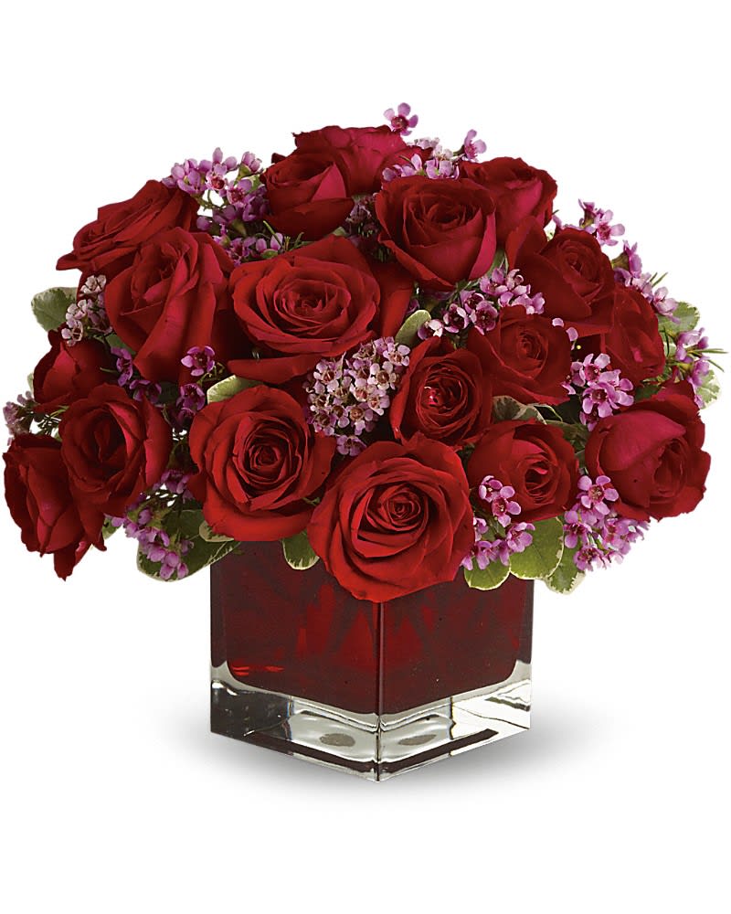 Never Let Go by Teleflora - 18 Red Roses - Let someone special know how much their love means to you by sending them this truly original arrangement. A vision in red with lavender accents this beautiful gift is a poignant way to celebrate love that endures. Eighteen pretty red roses with lavender waxflower and greens are delivered in a stunning ruby red cube vase.Approximately 12&quot; W x 11&quot; H