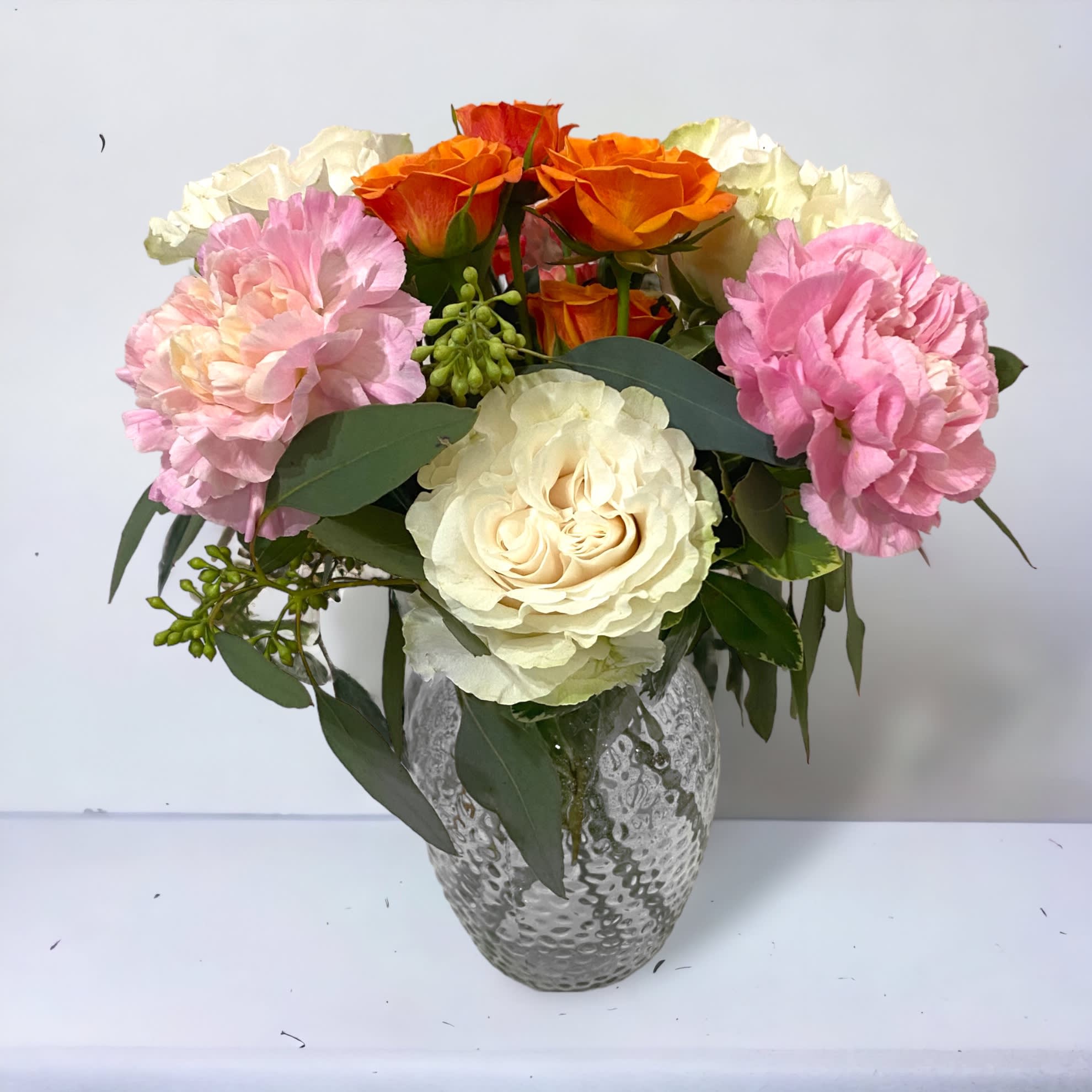 Bella  - A beautiful and symmetrical bouquet of roses, minami carnations and spray roses. Arranged in a glass vase. High quality and high value! 