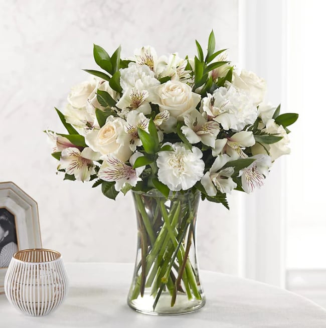 Cherished Friend Bouquet - For the friends who truly feel like family, share your thoughts and love with timeless white flowers. Our Cherished Friend Bouquet is comprised of a striking array of alstroemeria, carnations and roses. Each bloom combines your thoughtful messages with stunning texture.  Please Note: The bouquet pictured reflects our original design for this product. While we always try to follow the color palette, we may replace stems to deliver the freshest bouquet possible, and we may sometimes need to use a different vase. DETAILS 17&quot;h x 16&quot;w BLOOM DETAILS Carnation Rose