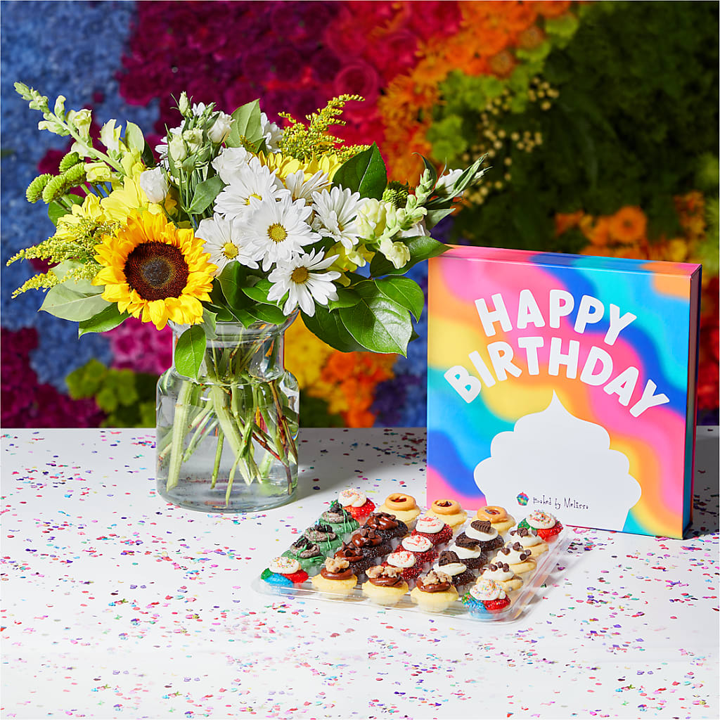 Hip Hip Hooray Birthday Bundle - Brighten their special day with bite–sized bliss from Baked by Melissa. This mouthwatering assortment includes 25 cupcakes baked to fluffy perfection, hand–stuffed, iced, and topped with magical ingredients like chocolate chips and real Oreo® cookies. Coupled with the joyful Hello Sunshine Bouquet, it's a brilliant way to celebrate another trip around the sun. DETAILS The cupcakes are packaged in a vibrant Birthday Box. The flowers are arranged locally by expert florists, ready to display. For long–lasting blooms, replace the water daily. We suggest trimming the stems every couple days. Pet Safety Precautions: This bouquet or plant may include flowers and foliage that are known to be toxic to pets. To keep them safe, be sure to keep this arrangement out of your pet's reach. Baked by Melissa treats are made in a facility that processes: Peanuts &amp; Tree Nuts. BLOOM DETAILS Sunflower Daisy Snapdragon ITEM: BBM2