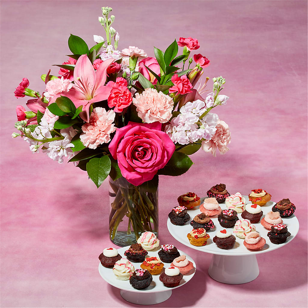 Sugar High Bouquet and 25 Cupcake Bundle - Carnations, roses, or lilies arrive fresh in the full spectrum of pink petals, so whatever flower you pick from the bunch will be sweet, like sugar. Paired with 25 bite-sized cupcakes, baked to fluffy perfection.  Please Note: The bouquet pictured reflects our original design for this product. While we always try to follow the color palette, we may replace stems to deliver the freshest bouquet possible, and we may sometimes need to use a different vase.  Baked by Melissa cupcakes are packaged in a custom-made, pocketed clamshell pack that keep treats safe &amp; perfectly fresh for up to 2 weeks when stored in the freezer, and up to 48 hours at room temp when stored in the closed pack. DETAILS Includes 25 cupcakes. The flowers are arranged locally by expert florists, ready to display. For long–lasting blooms, replace the water daily. We suggest trimming the stems every couple days. Pet Safety Precautions: This bouquet or plant may include flowers and foliage that are known to be toxic to pets. To keep them safe, be sure to keep this arrangement out of your pet's reach. This product contains eggs, milk, peanuts, soy, and wheat. All Baked by Melissa treats are made in a bakery that processes peanuts, tree nuts, and other allergens. All Baked by Melissa treats are vegetarian and baked in a central dairy Kosher-certified kitchen.  CUPCAKE FLAVORS 5x Dark Chocolate 4x Marshamllow 4x Dulce de Leche 4x Brookie 4x Red Velvet 4x Strawberry BLOOM DETAILS Carnation Lily Rose Stock ITEM: L5482D-BBM