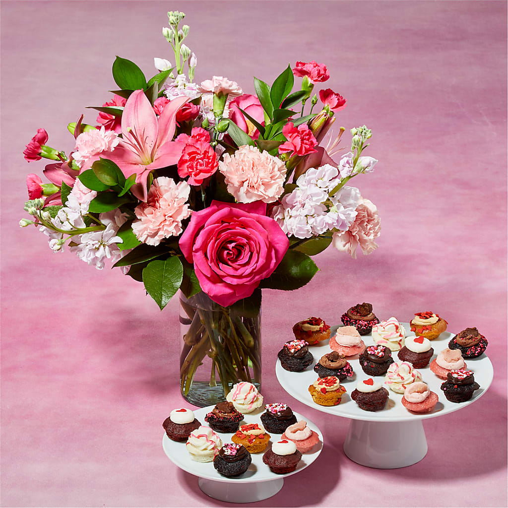 Sugar High Bouquet and 25 Cupcake Bundle Sugar High Bouquet and 25 Cupcake Bundle - Carnations, roses, or lilies arrive fresh in the full spectrum of pink petals, so whatever flower you pick from the bunch will be sweet, like sugar. Paired with 25 bite-sized cupcakes, baked to fluffy perfection. Please Note: The bouquet pictured reflects our original design for this product. While we always try to follow the color palette, we may replace stems to deliver the freshest bouquet possible, and we may sometimes need to use a different vase. Baked by Melissa cupcakes are packaged in a custom-made, pocketed clamshell pack that keep treats safe & perfectly fresh for up to 2 weeks when stored in the freezer, and up to 48 hours at room temp when stored in the closed pack. DETAILS Includes 25 cupcakes. The flowers are arranged locally by expert florists, ready to display. For long–lasting blooms, replace the water daily. We suggest trimming the stems every couple days. Pet Safety Precautions: This bouquet or plant may include flowers and foliage that are known to be toxic to pets. To keep them safe, be sure to keep this arrangement out of your pet's reach. This product contains eggs, milk, peanuts, soy, and wheat. All Baked by Melissa treats are made in a bakery that processes peanuts, tree nuts, and other allergens. All Baked by Melissa treats are vegetarian and baked in a central dairy Kosher-certified kitchen. CUPCAKE FLAVORS 5x Dark Chocolate 4x Marshamllow 4x Dulce de Leche 4x Brookie 4x Red Velvet 4x Strawberry BLOOM DETAILS Carnation Lily Rose Stock ITEM: L5482D-BBM