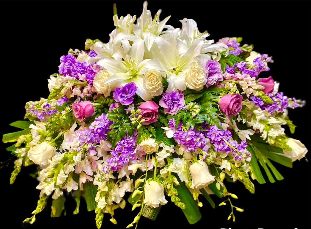 Peaceful Serenity Peaceful Serenity - This elegant design is composed of various luxurious blooms such as Oriental Lilies, Dendrobium Orchids, Lavender and White Roses, Snapdragon, Stock, and Lisianthus, combined with various lush complementary foliage. This design measures approx. 14"H x 36"W. This design must be ordered at least 72 hours in advance.