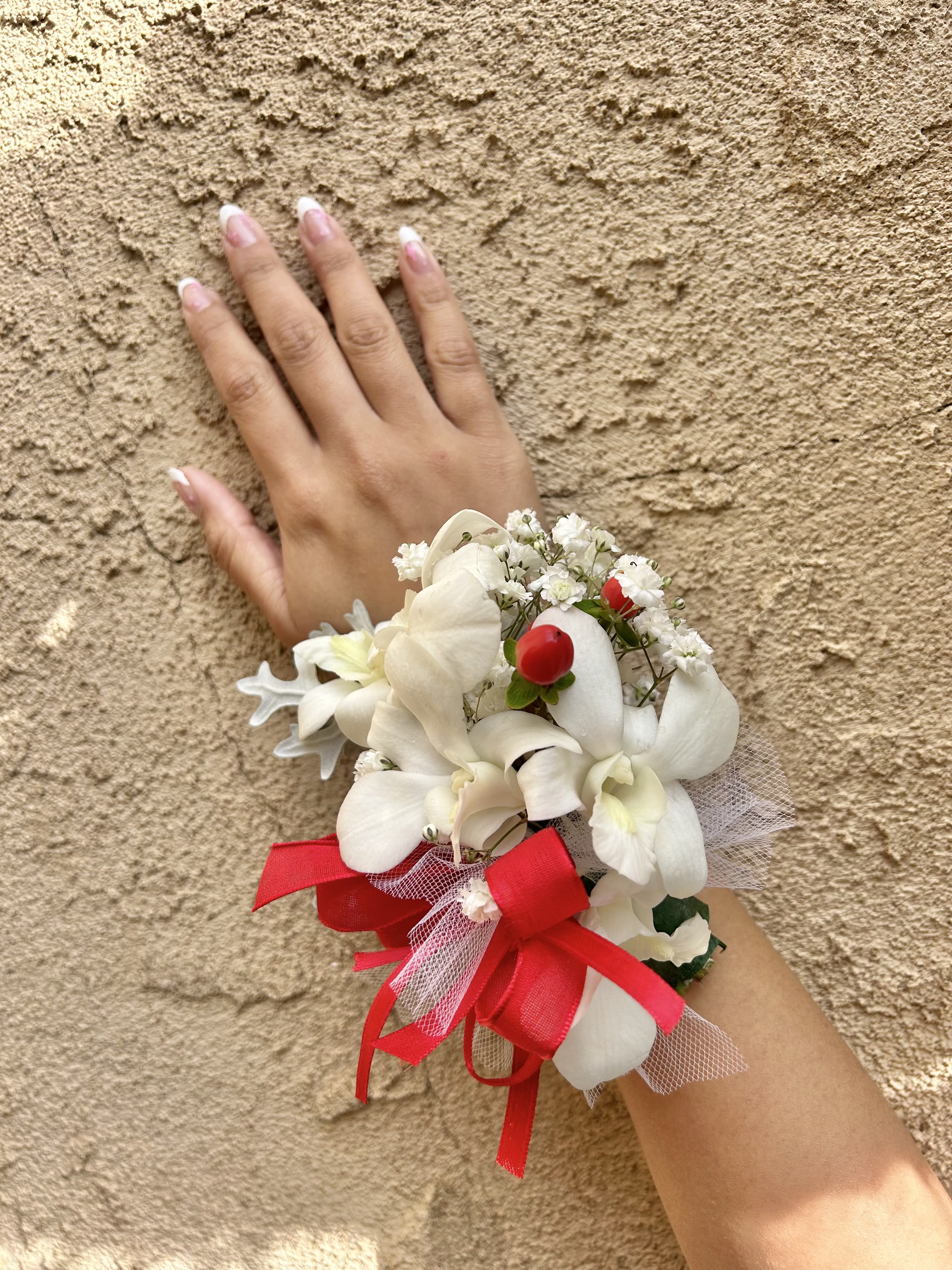 Wrist Corsage 10 - Wrist corsage with white and red flowers with accents. CUSTOMER CAN CHOOSE ANY COLOR STANDARD: WRIST CORSAGE DELUXE: WRIST CORSAGE + BOUTONNIERE