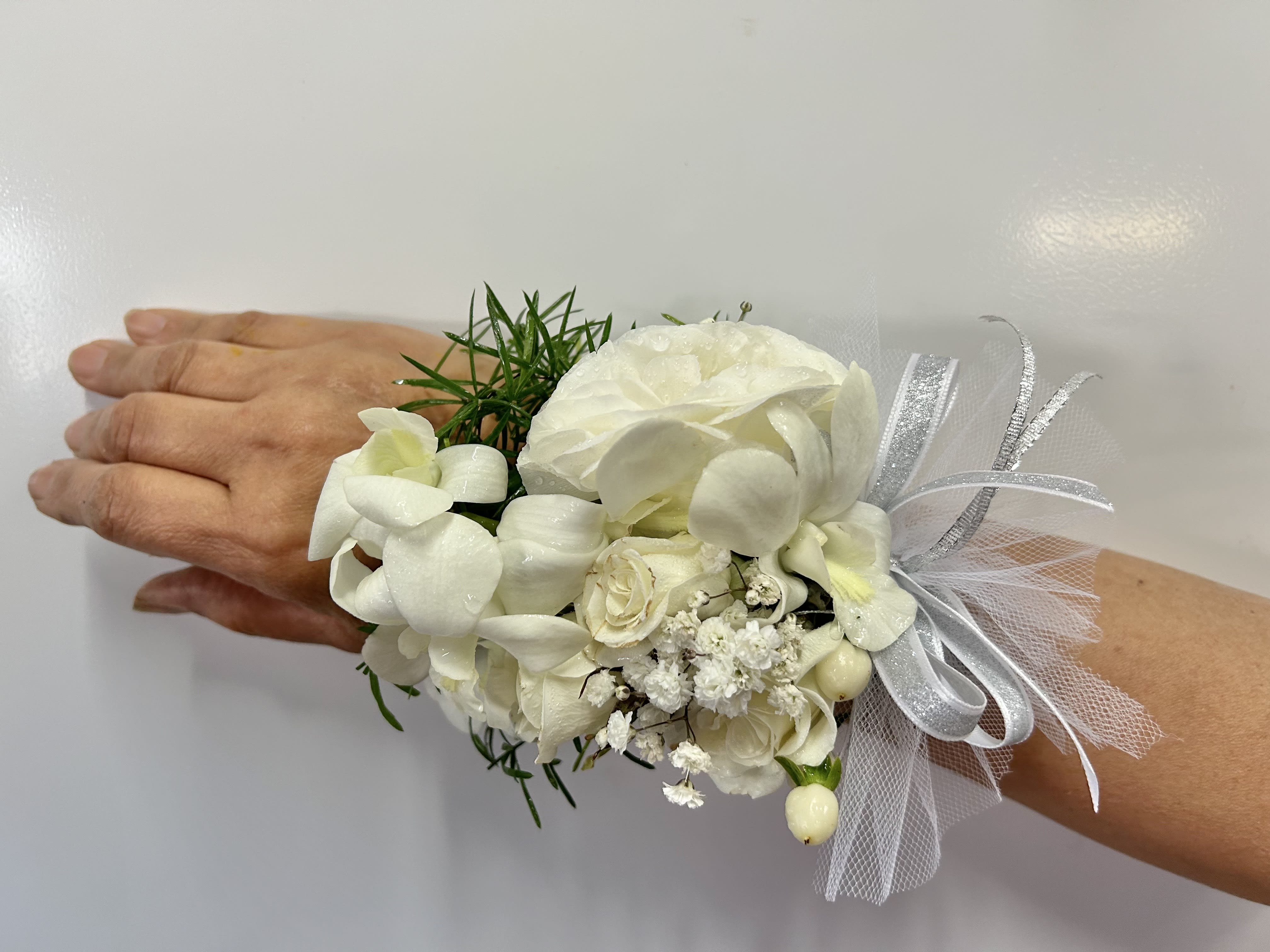 Wrist Corsage 16 - Wrist corsage with white flowers and accents. CUSTOMER CAN CHOOSE ANY COLOR STANDARD: WRIST CORSAGE DELUXE: WRIST CORSAGE + BOUTONNIERE