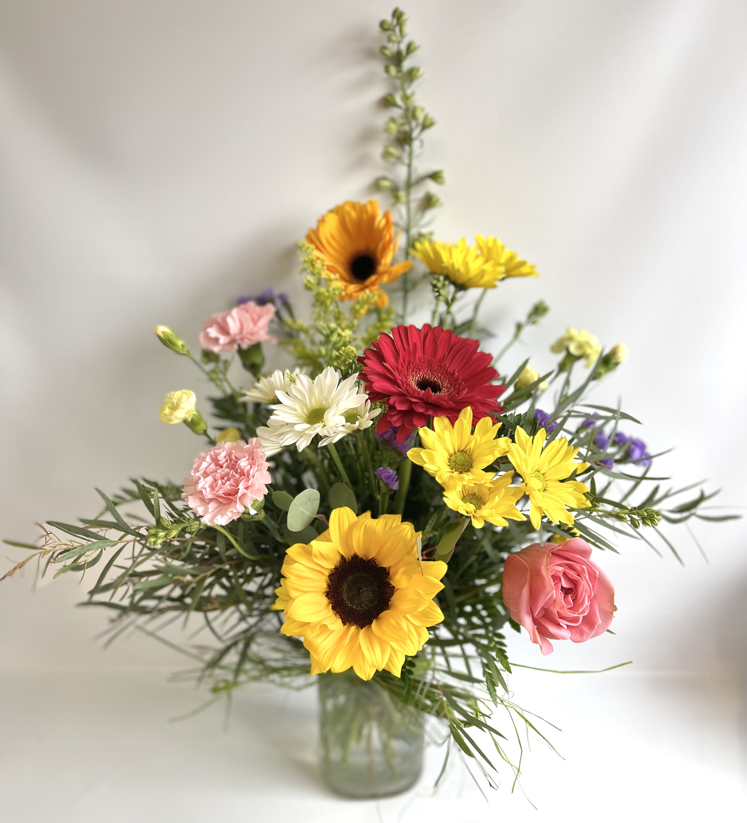 Garden Delight  by Barb’s Flowers - This bouquet is full of color. Sunflowers, Gerbera Daisy, Carnations, Daisies and Garden Rose. 