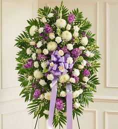 Elegant and Memorable Tribute Elegant and Memorable Tribute - - - Lavender and white. Small funeral standing spray. Elegant and memorable tribute. with a wire easel honor with love with this arrangement.