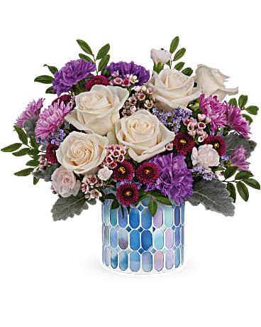 Blue Beauty Bouquet - pringtime beauty at its best! Creamy roses and deep purple blooms are oh-so-alluring in this shimmering, stained glass mosaic vase. Crème roses, purple carnations, miniature light pink carnations, lavender cushion spray chrysanthemums, purple button spray chrysanthemums, pink waxflower and purple limonium are arranged with dusty miller and huckleberry. Delivered in Teleflora's Blue Beauty Mosaic vase.