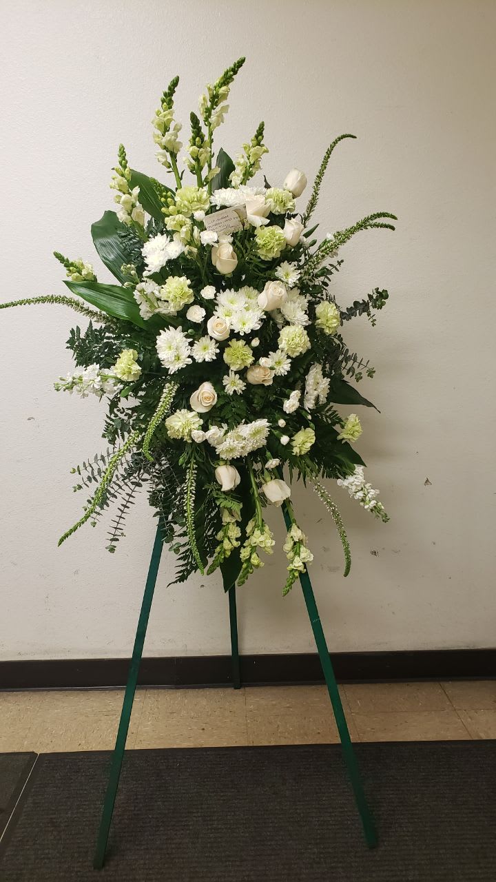 Magnificent White Magnificent White - beautiful arrangement that give you comfort and peace. 10 White snap dragon. 4 white stock, 9 white roses. 6 white cushion , 8 white veronicas, 10 white carnation. spirals eucalyptus, aspidistra leaves and greeneries.
