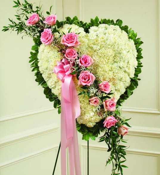 White and Pink Heart - Honor a loved one with this standing heart-shaped arrangement that celebrates someone dear. White carnations create a solid heart that is accented with a pink rose break. It will be a loving and lasting tribute to a very special person.