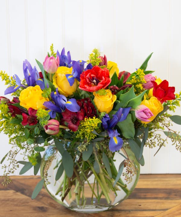 Mama Drama - This dramatic bouquet includes bright yellow roses, vibrant red alstroemeria, striking blue iris, elegant solidago, bold tulips, and seeded eucalyptus. This arrangement is perfect for Mom who loves drama and flair in her life. The contrasting colors and textures make a stunning display that is sure to brighten up any room. Give Mama Drama as a gift to show your mom how much you appreciate her and all the excitement she brings to your life.