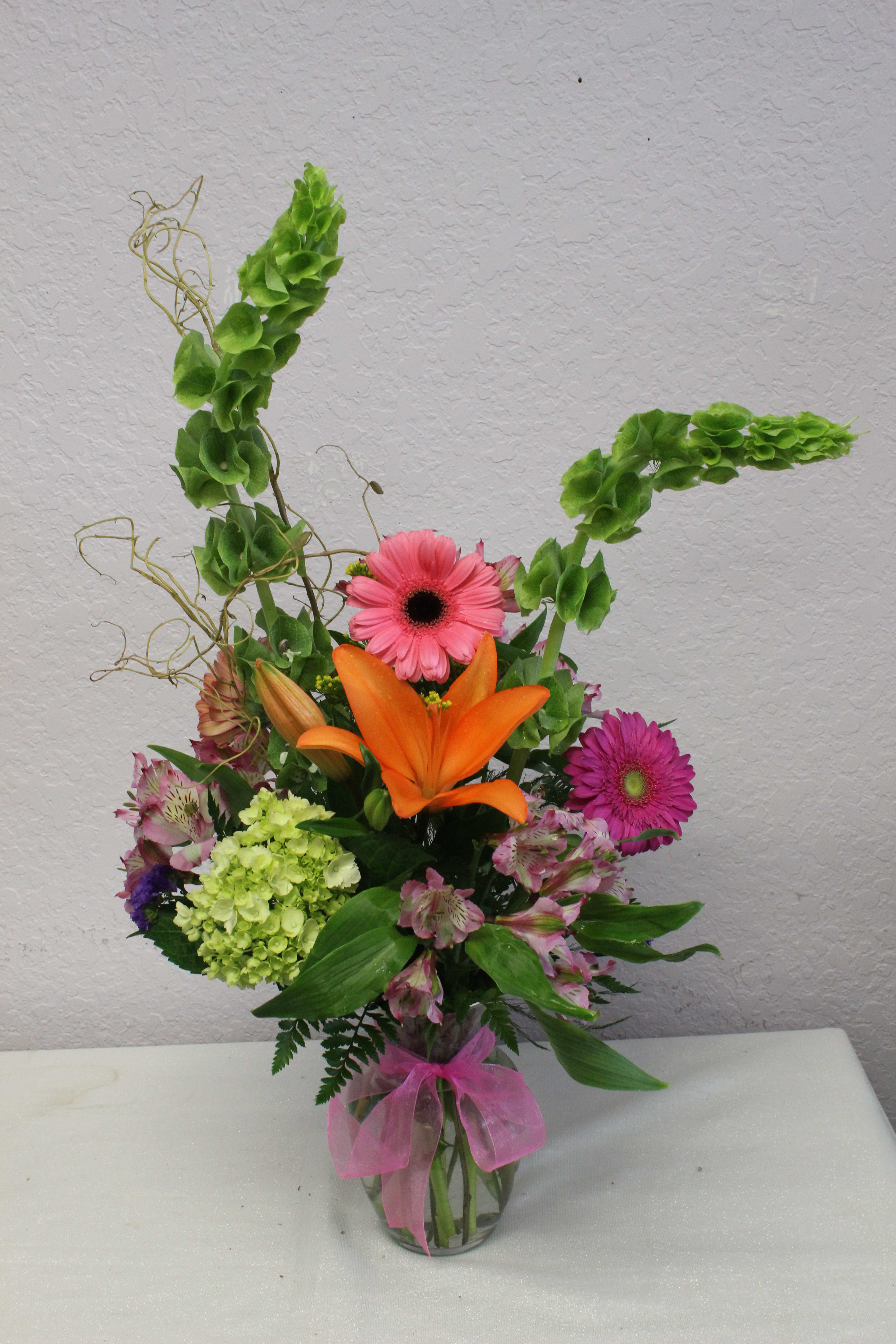 CFM106 CFM106 - A beautiful vased arrangement of Asiatic lilies, Gerbera Daisies, Alstroemeria, Hydrangea and other flowers in beautiful spring colors.