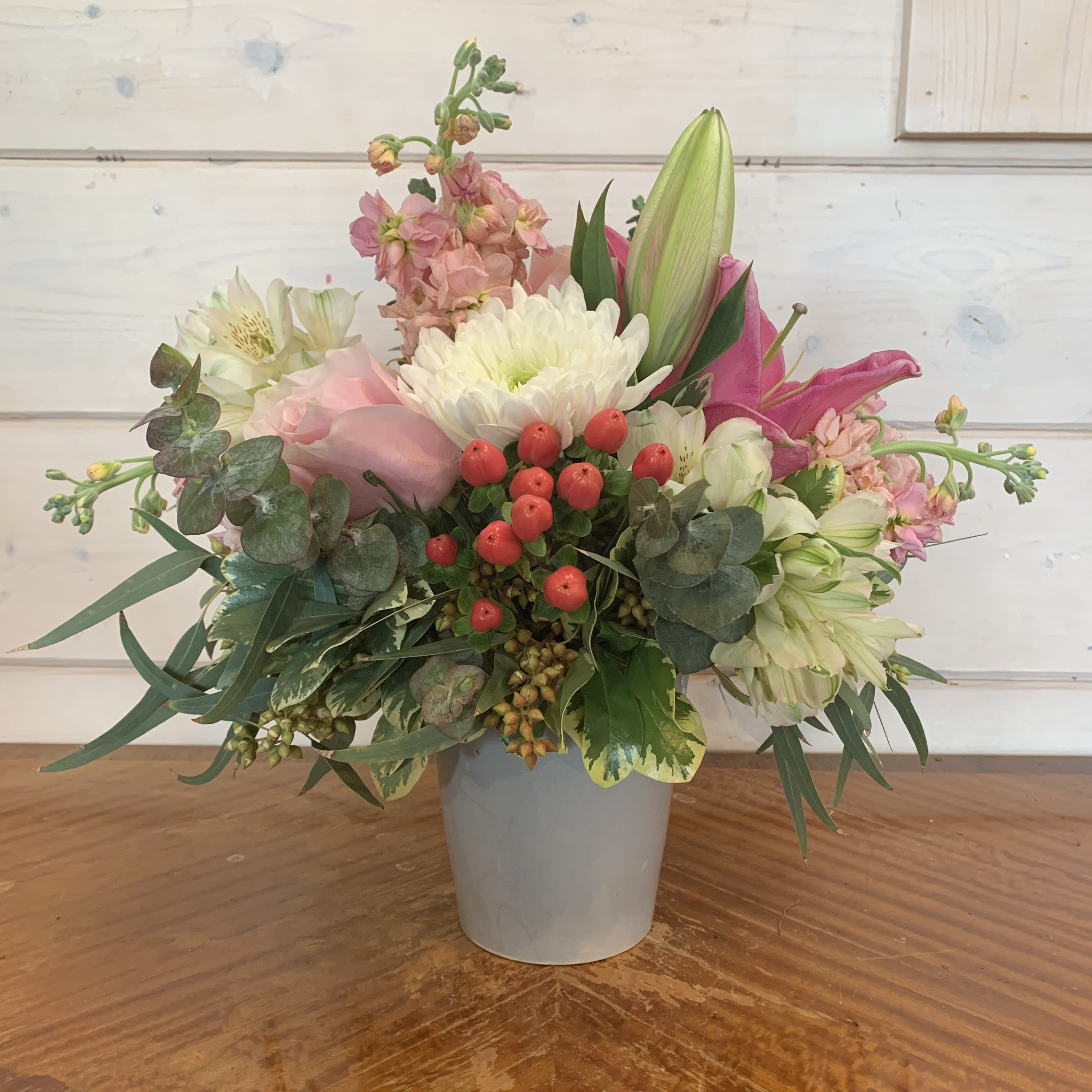 Pastel Pinks Bouquet  - Pale pink roses, pink lily, peach stock, white cremon chrysanthemums and alstromeria arranged in a grey cache pot with hypericum berries and mixed eucalyptus. Approximately 12in tall and 12in wide. 