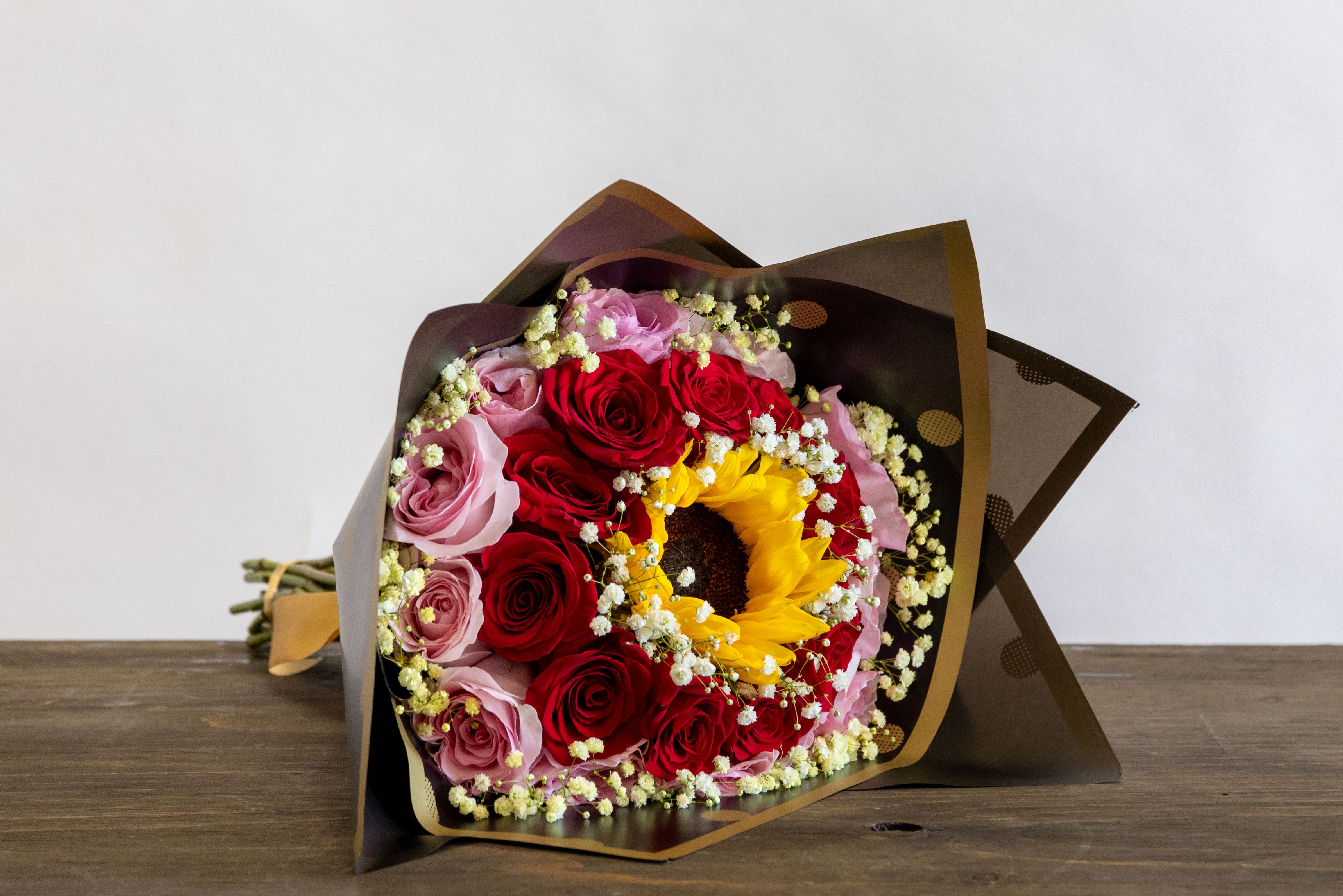 Mixed Berries Mixed Berries - Two toned rows of roses with a sunflower in the middle and angels breath at the edge