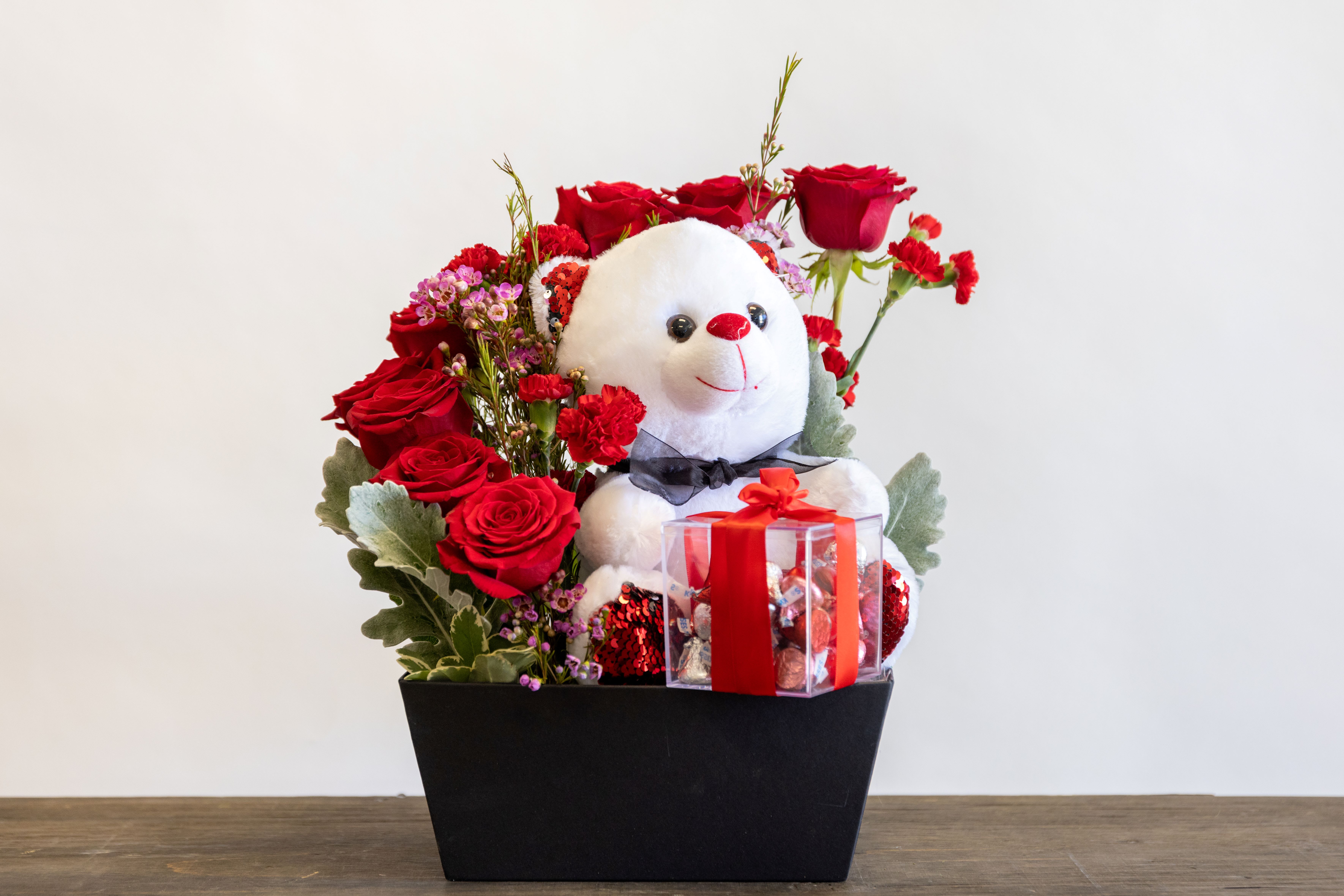 Teddy - Roses arranged in a cascading form wrapping around a plush bear