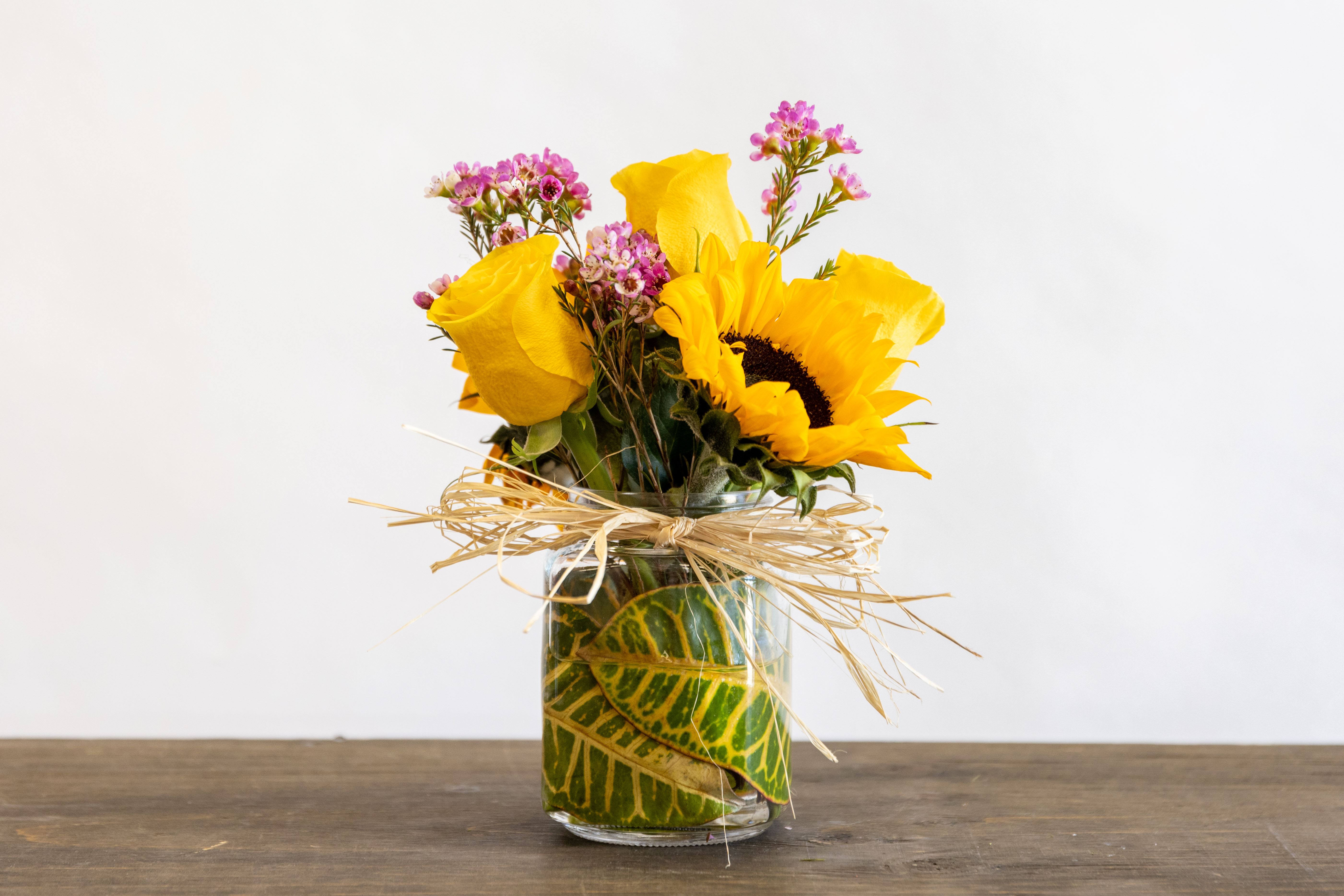 Sunflower doll - A small three rose and a sunflower arrangement 