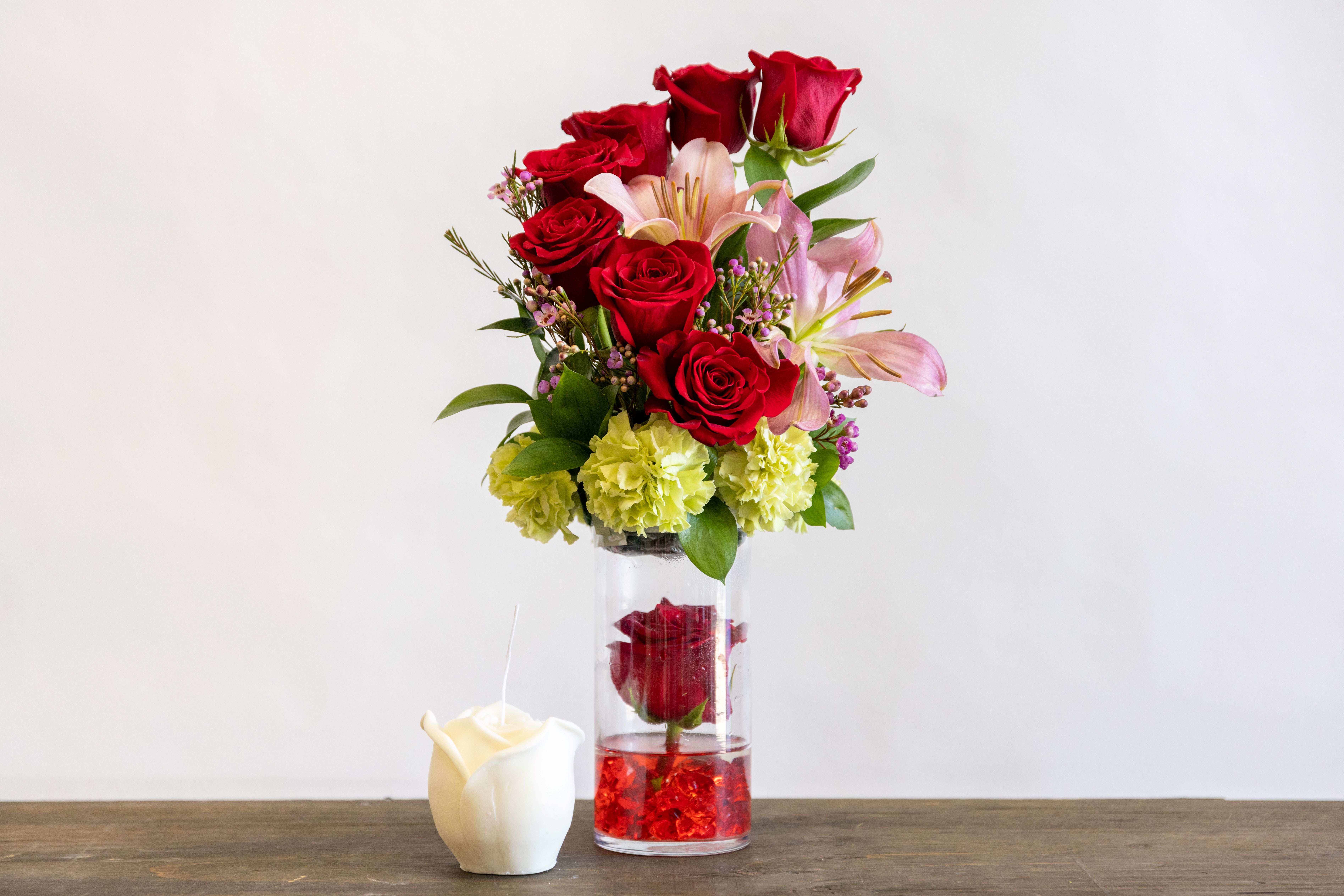 Drowned - A tall vase of roses and a lily with a single rose submerged in the vase with magic