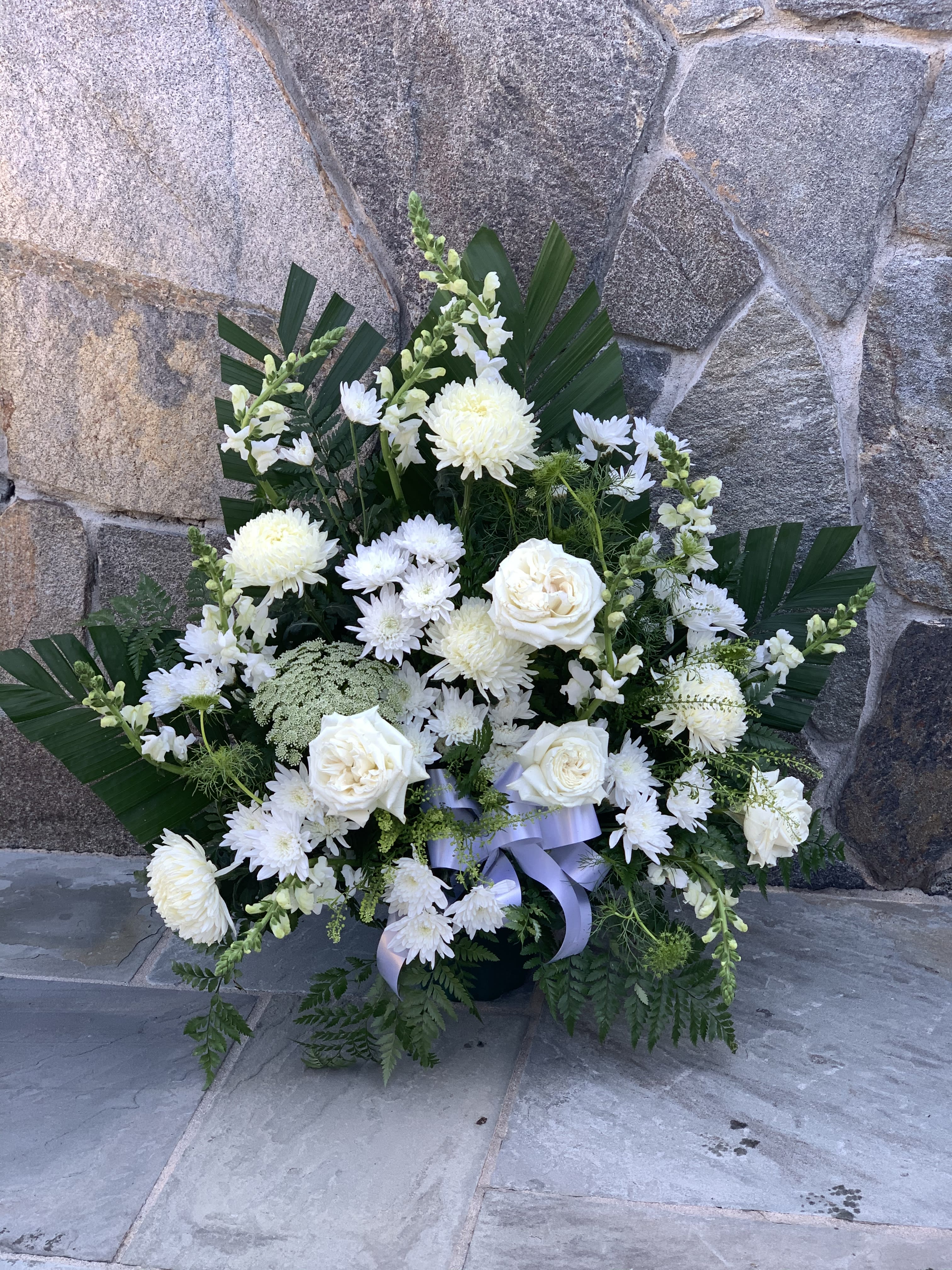 Sympathy basket 01 - The blooms used may vary by the season and availability, and since each arrangement is custom-made to order by our talented designers, They will all look slightly different, which is what makes them so special! The photo is a representation of the overall look of this modern arrangement.