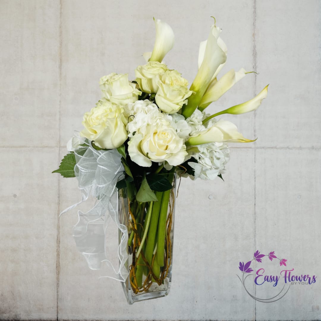 Thoughtful Reflection - Experience the breathtaking beauty of all-white floral design featuring calla lilies, roses, and hydrangeas. Our stunning arrangement will add a touch of elegance and sophistication to any occasion.