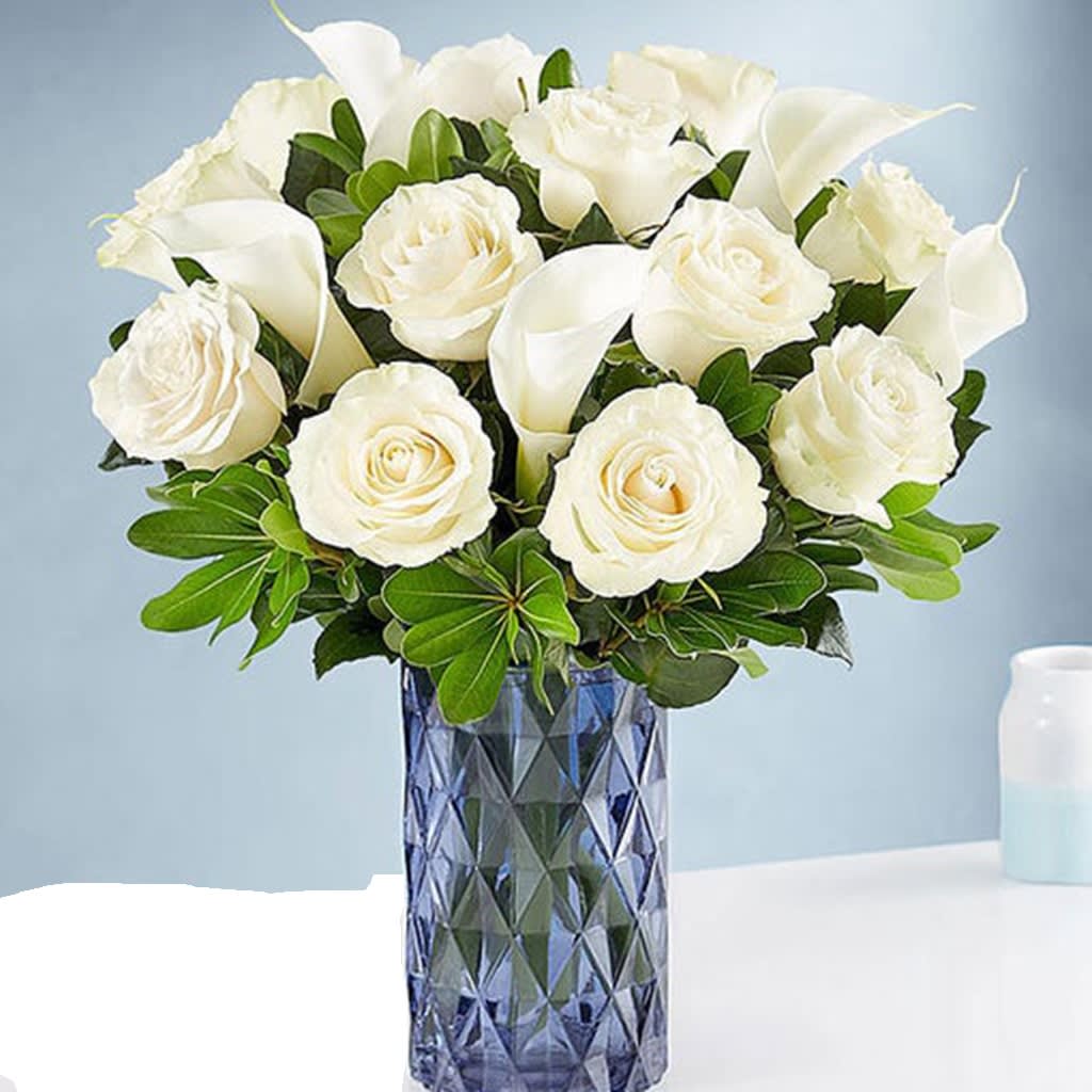 White Rose & Calla Lily Bouquet White Rose & Calla Lily Bouquet - white roses and calla lilies is designed in a modern blue glass vase, bringing style and elegance to their day.