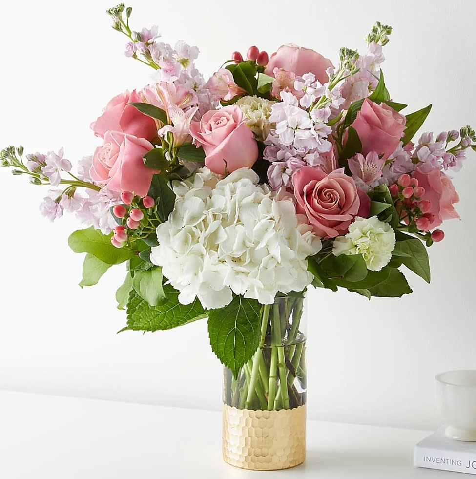 The April Bouquet The April Bouquet - Tickle them pink with this elegant arrangement of roses, alstroemeria, hypericum berries, and carnations set in a gold–dipped vase. As elegant as a string of pearls, add a touch of class to any room with roses and gerbera daisies.