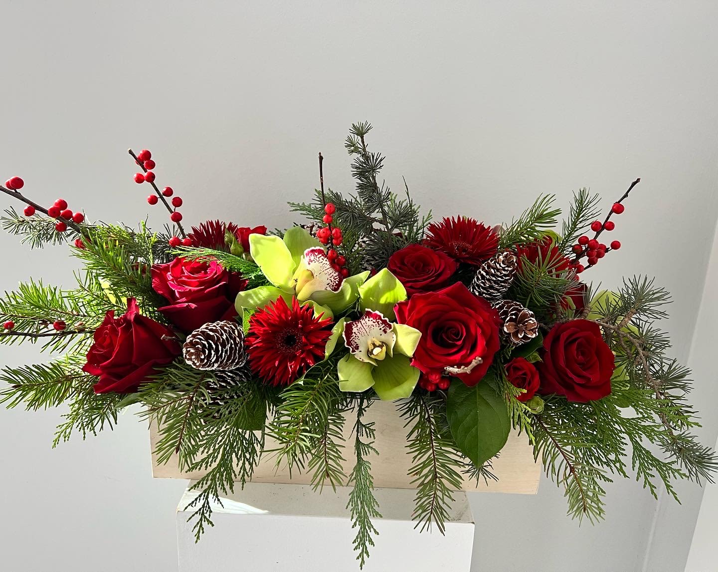 Christmas spirit - Christmas centerpiece in a box with roses, orchids, gerbera daisies, berries and pinecones