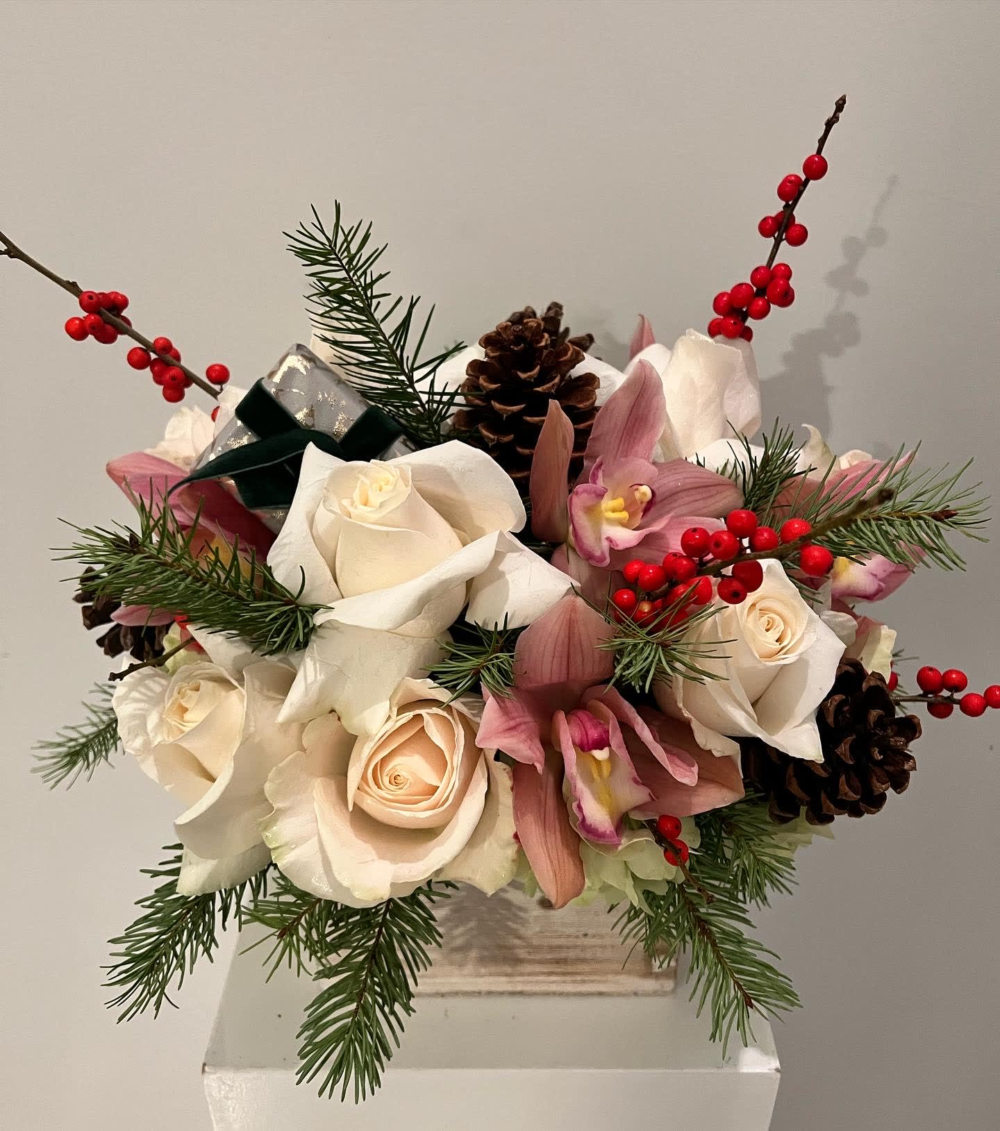 Christmas celebration - Holiday arrangement with roses, orchids, berries and pinecones